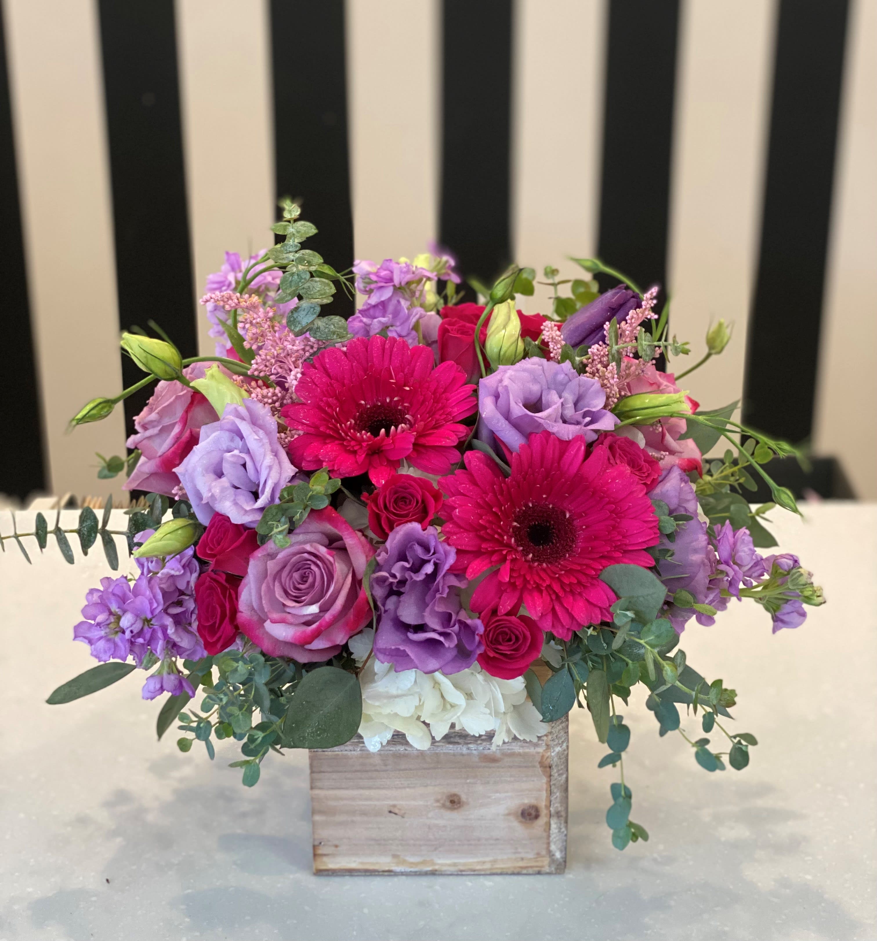 Pink and purple bouquet in a wooden box
