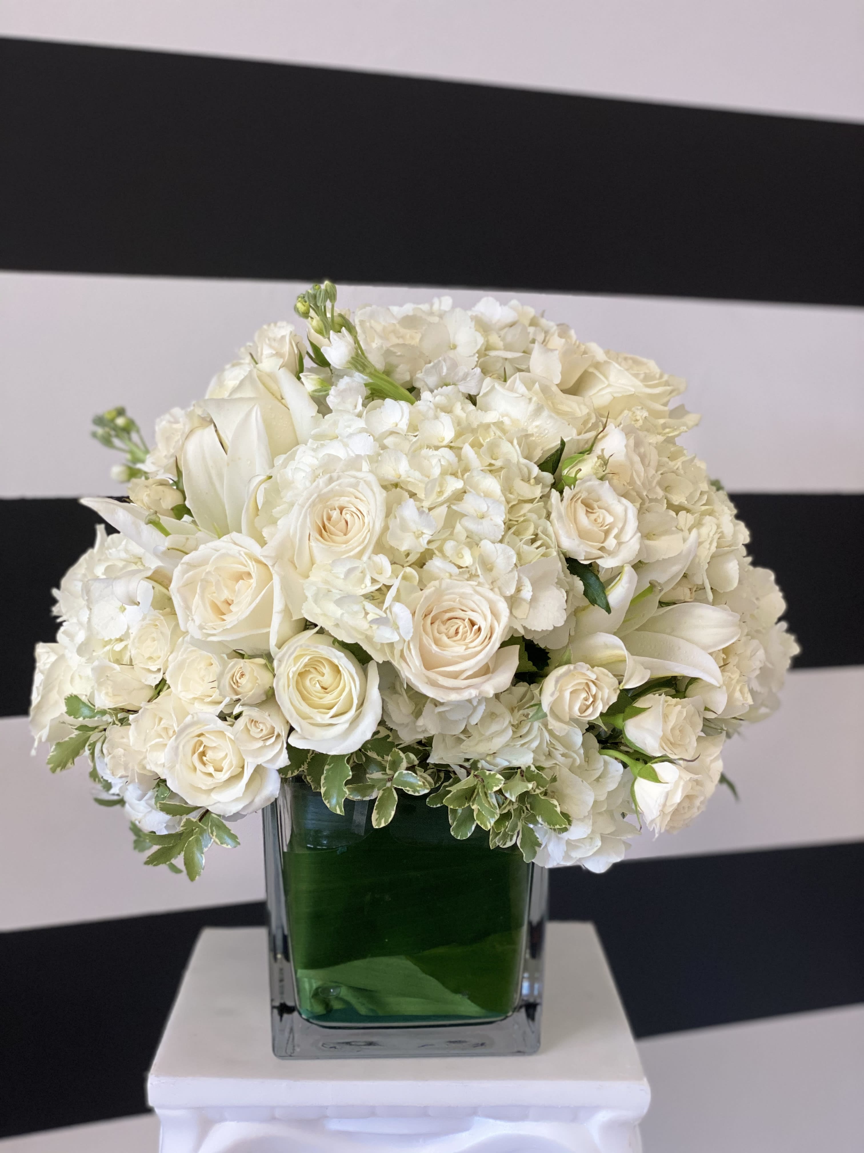 White Elegance Centerpiece - 6x6 glass cube vase with white lilies, white roses, white Stock and white Spray roses