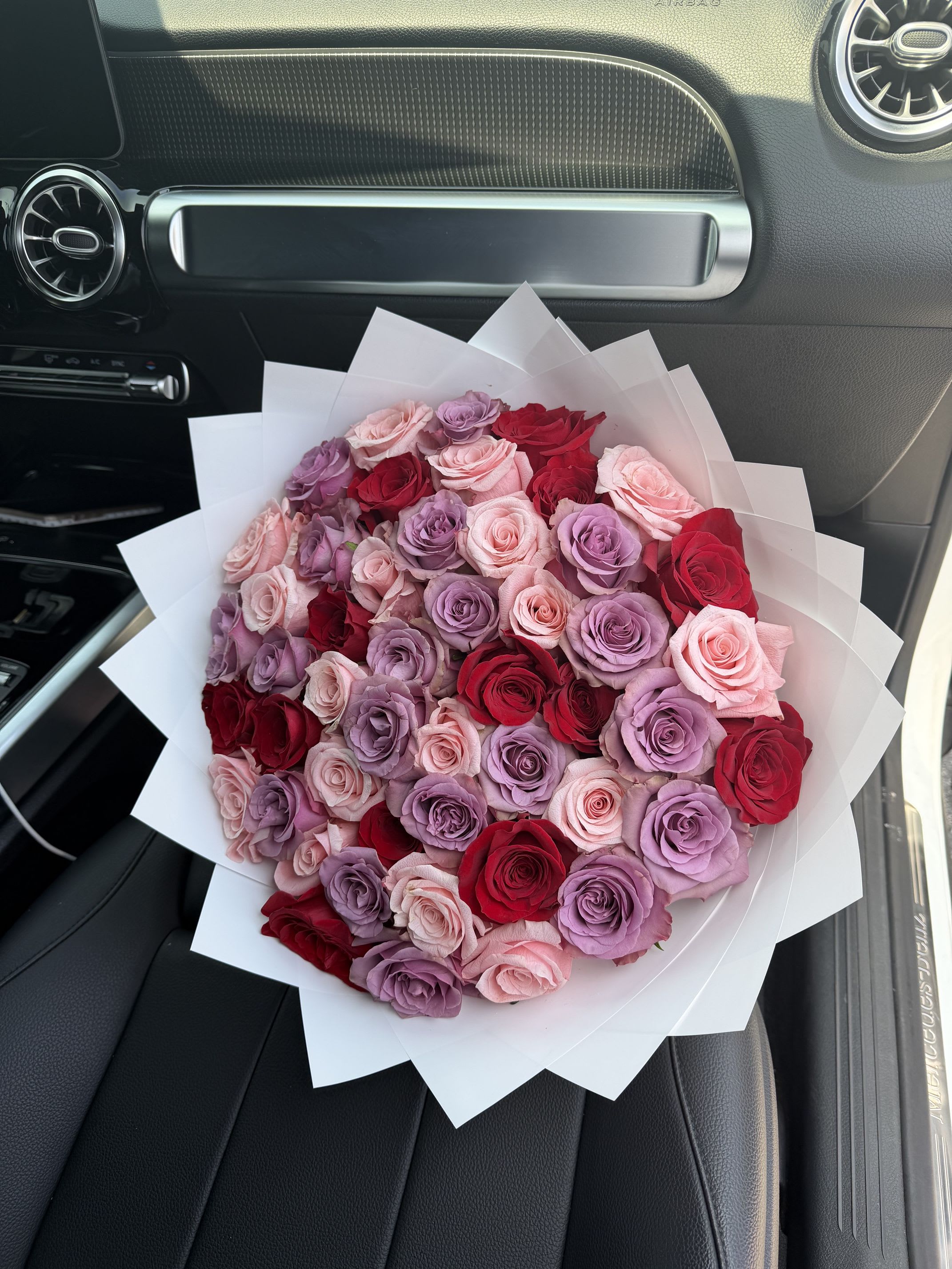 Sweet Surprise Bouquet - This unique and playful bouquet features two-toned roses surrounded by a mix of beautiful small possies, all wrapped in paper. Perfect for expressing your love and bringing a joyful touch to any occasion.