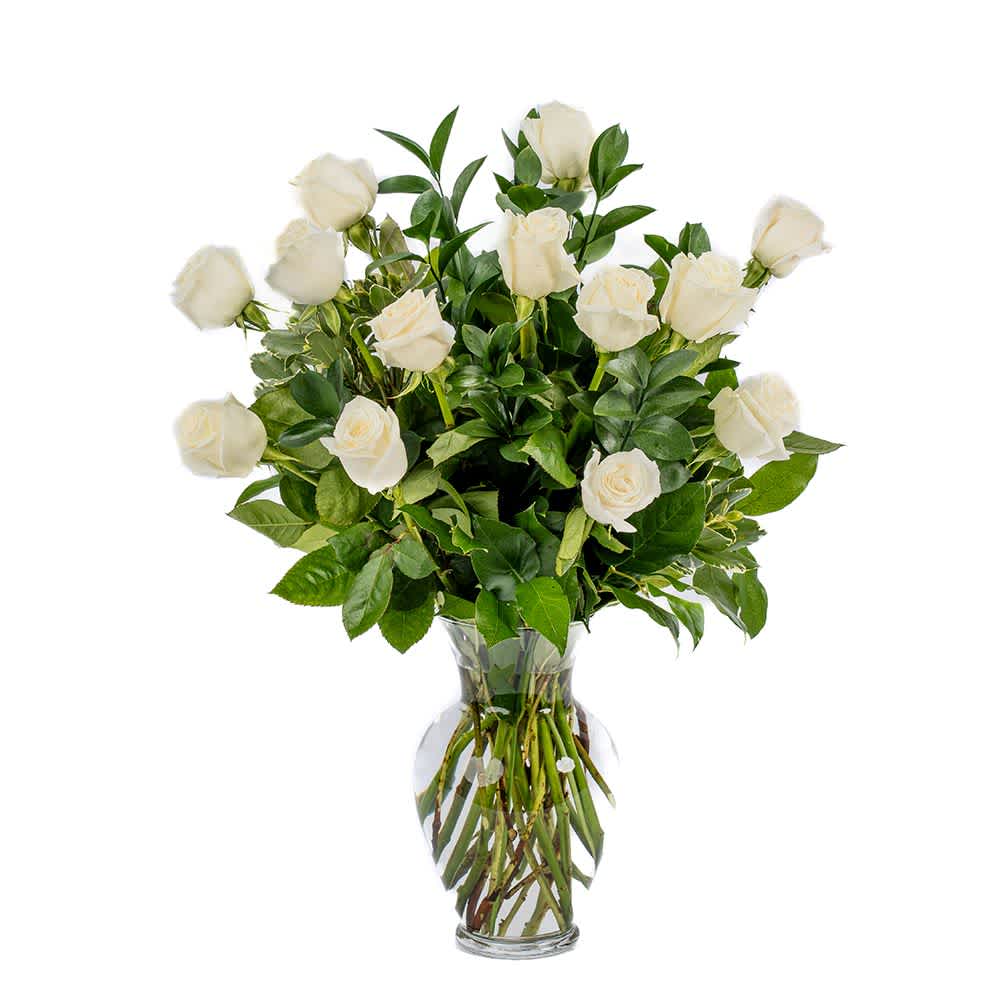 Tall arrangement of long-stem white roses in a clear glass vase