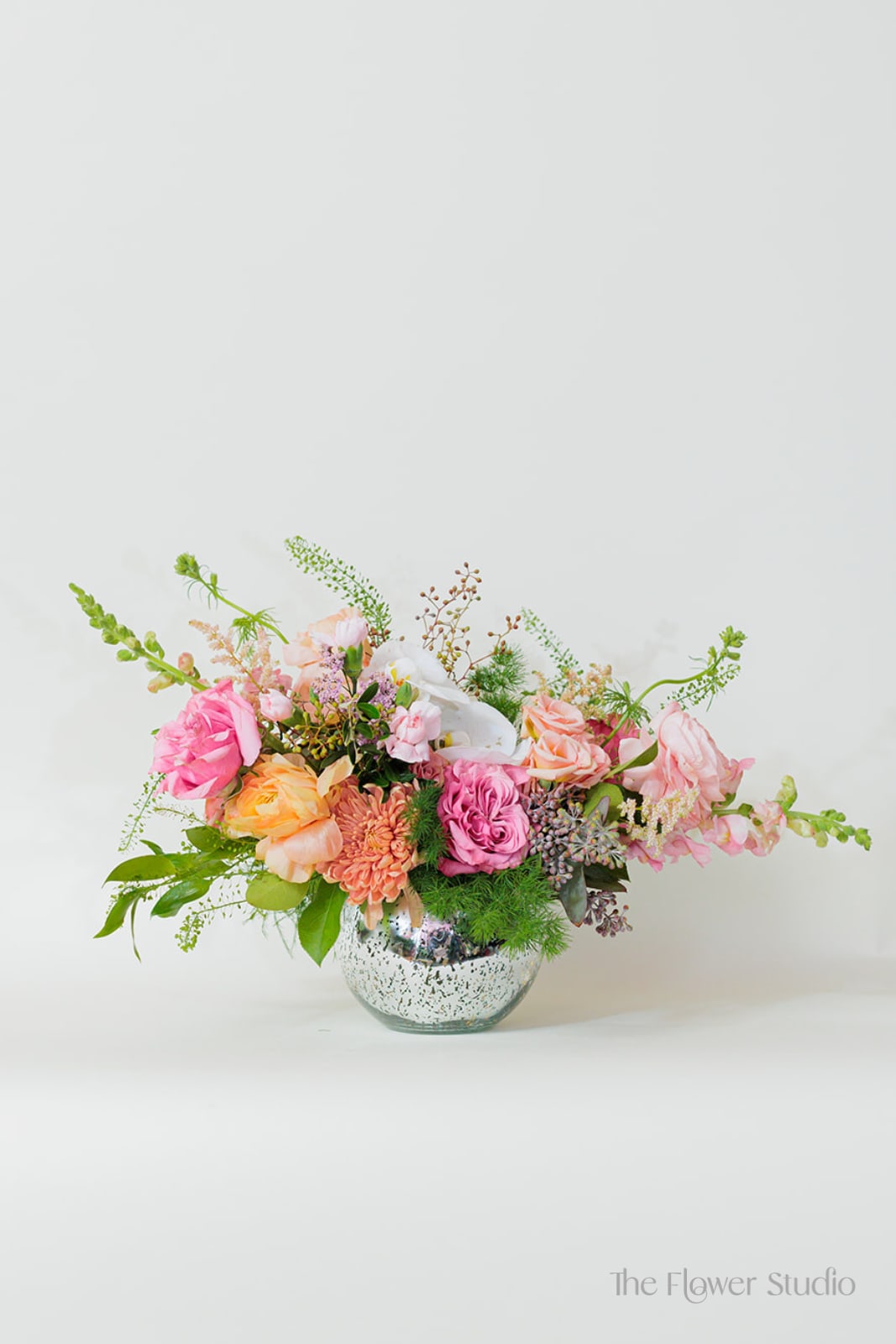 Mixed pink and peach flowers in a clear glass vase