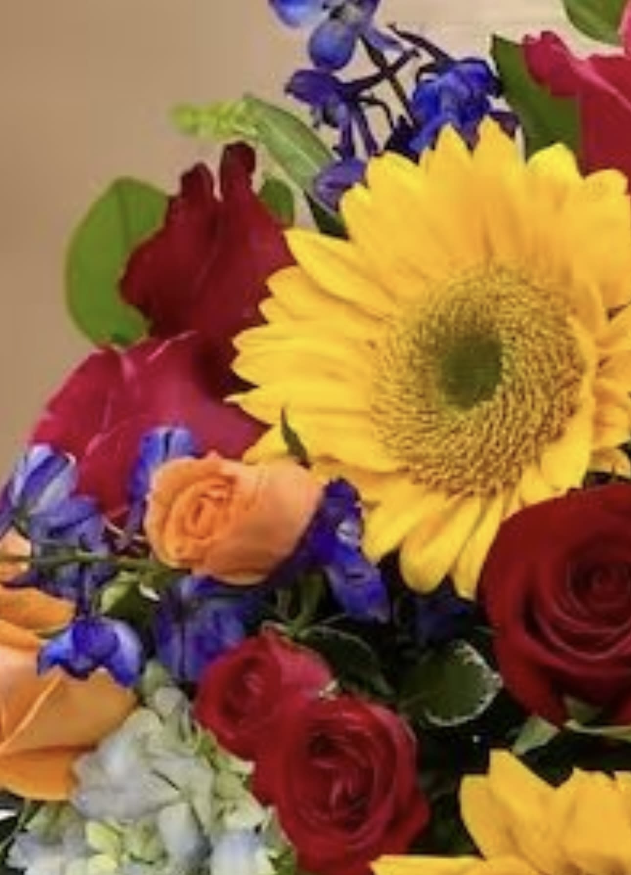 Mixed bouquet with a large yellow sunflower and red roses
