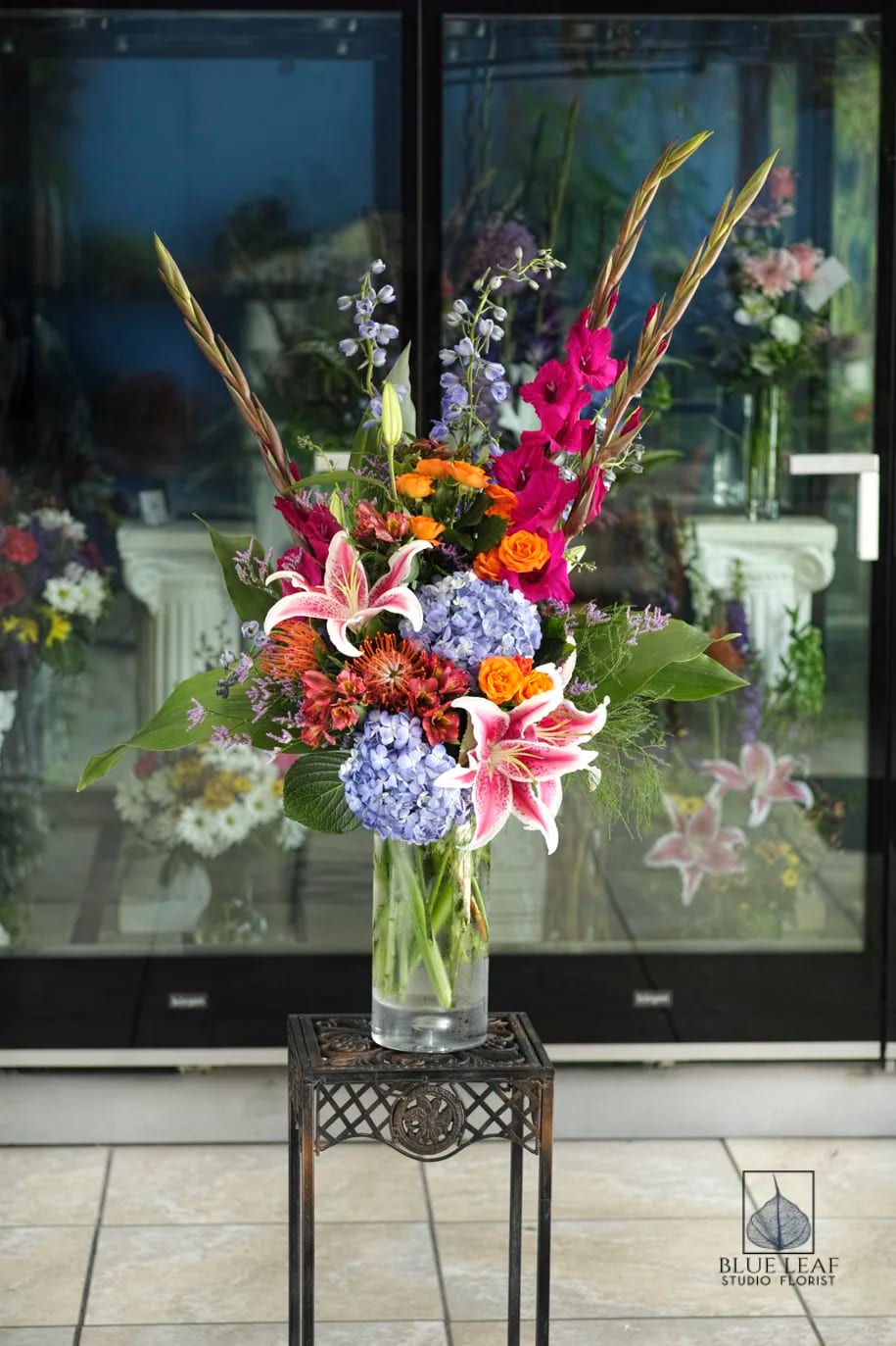 Vivid Vase - This vivid, one-of-a-kind arrangement shows off a fabulous color palette of blooms. Included are blue hydrangea, stargazer lilies, orange alstromeria, and hot pink gladiolas. 