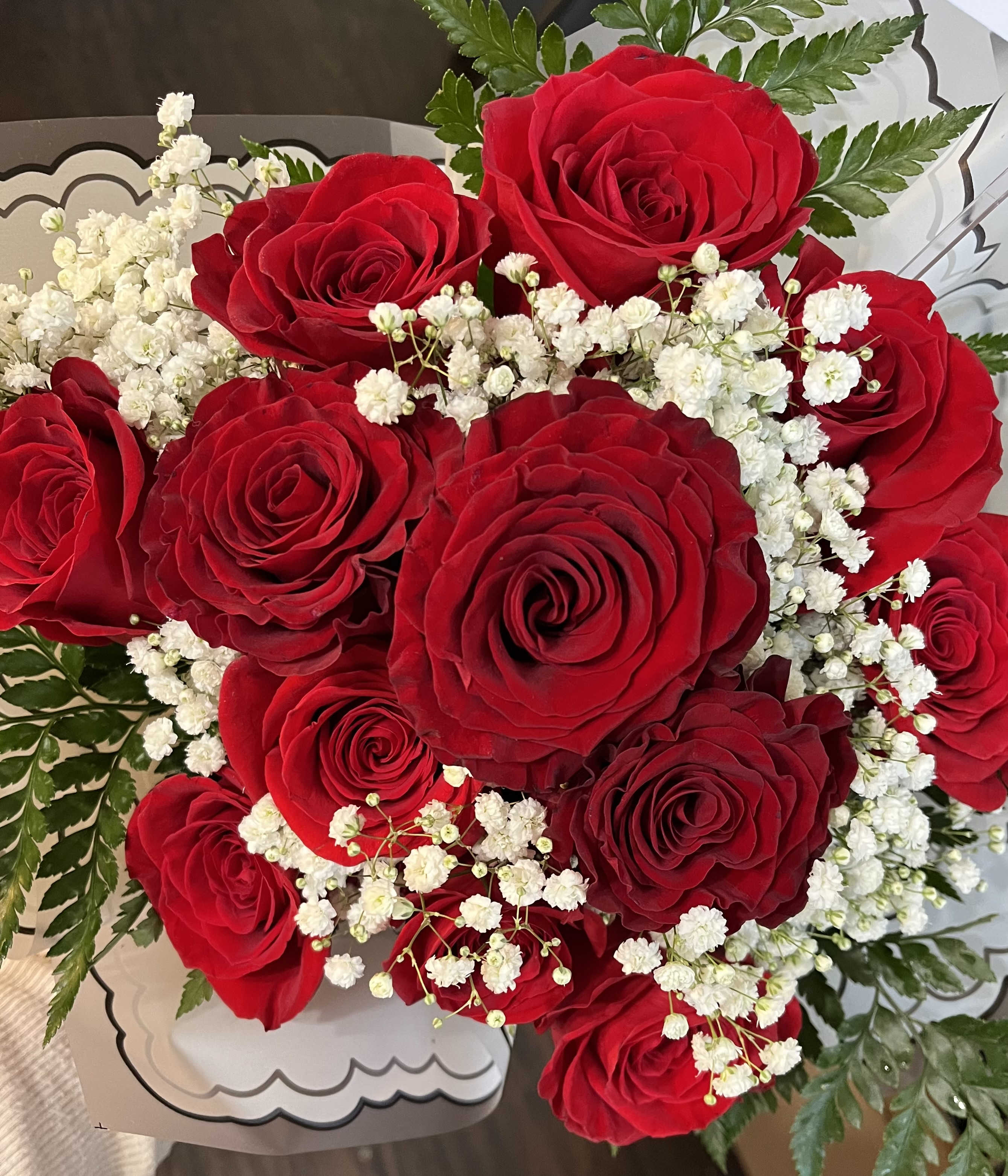 Bouquet of red roses with white baby's breath in decorative wrap