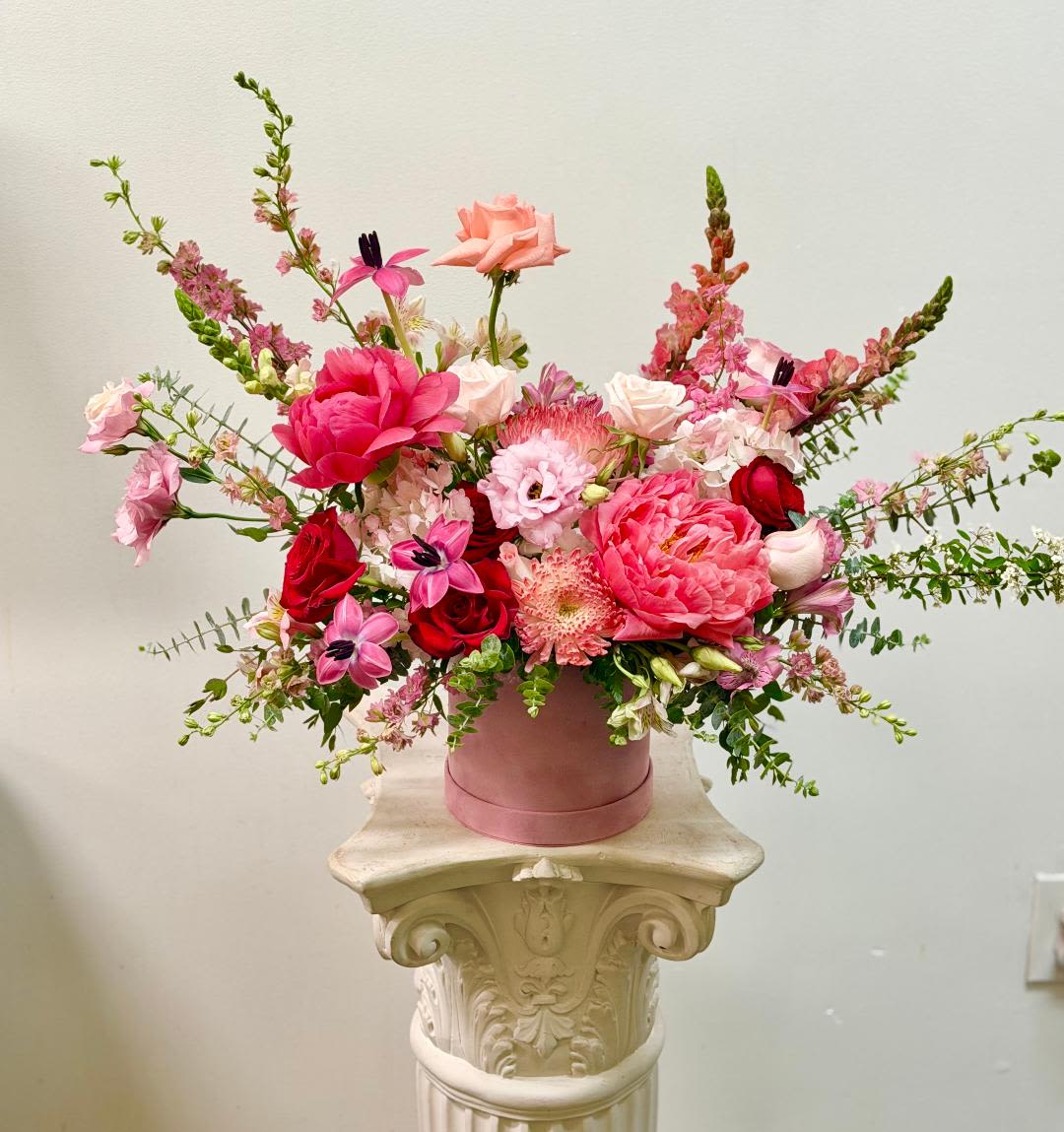 Raspberry Peony Box - Theme Colors: Shades of pinks and Red  Featured Blooms: Roses, Tulips, Peony, Spider, Hydrangea, Larkspur, Lisianthus, Alstroemeria, with Seasonal Blooms, in pink Box .  HK Flowers have a uniqueness of florals and seasonal blooms, certain flowers or colors may not be available as each season affects the availability, color, size, and shape of each floral bloom. Some flowers may be substituted accordingly.  Photos are used as a reference for the color palette and is NOT indicated of the final product. We ask for your trust in us that we will pick out the best seasonal available blooms, while still capturing the arrangements theme and colors mentioned above.