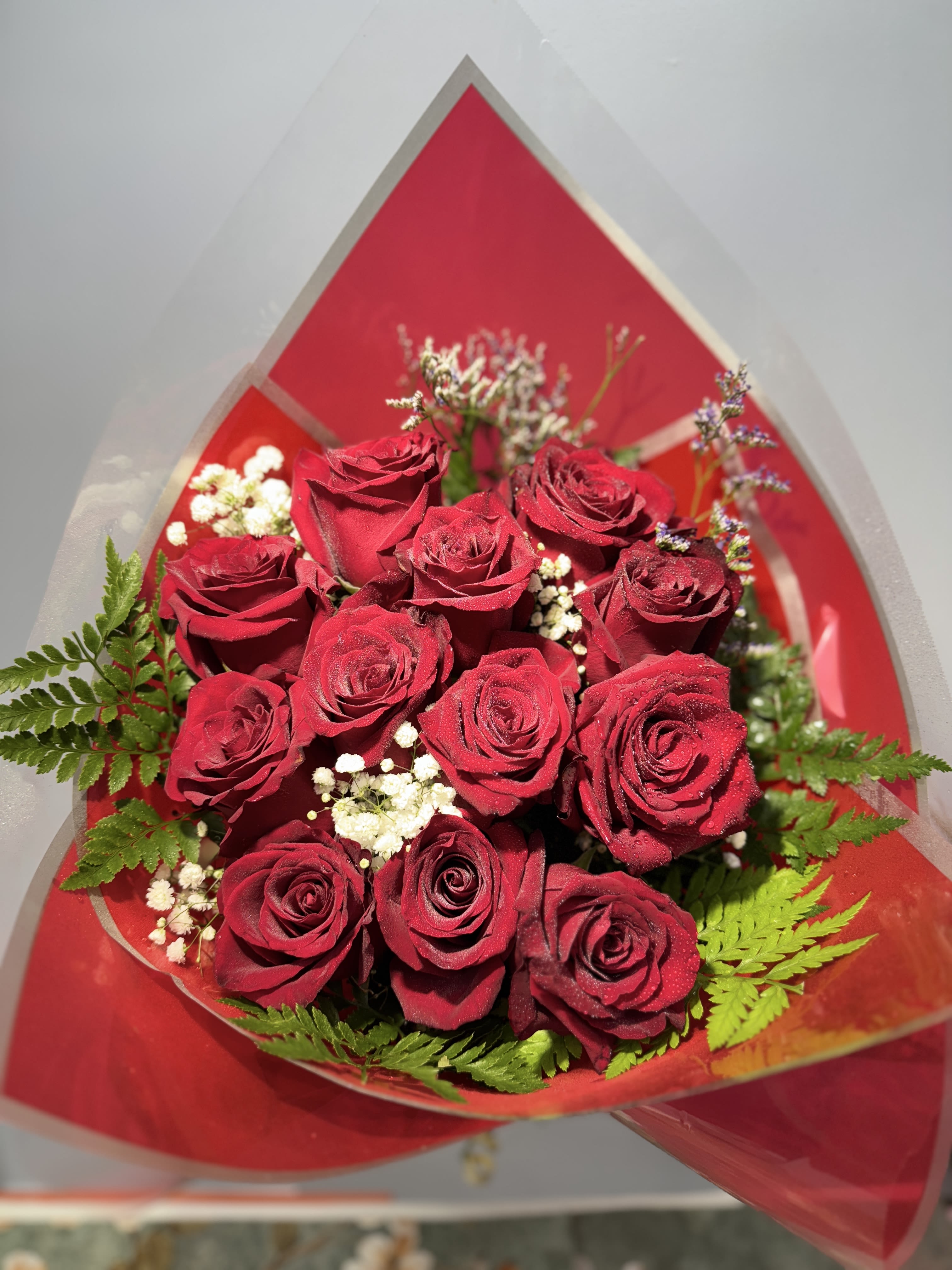 Bouquet of red roses with white filler flowers and fern leaves