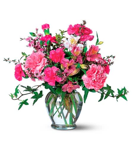 Pink mixed bouquet in a clear glass vase with trailing ivy