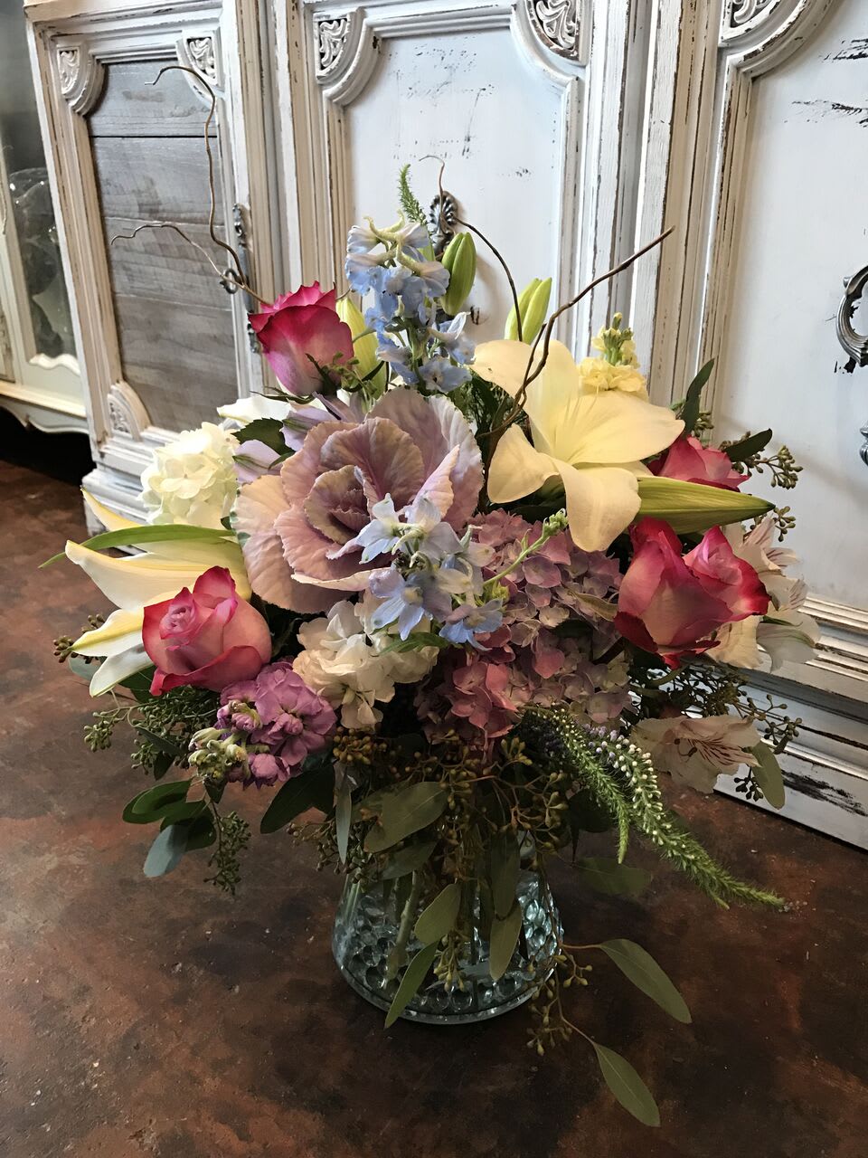 Mixed bouquet with pink roses, lilies, and hydrangeas in a glass vase