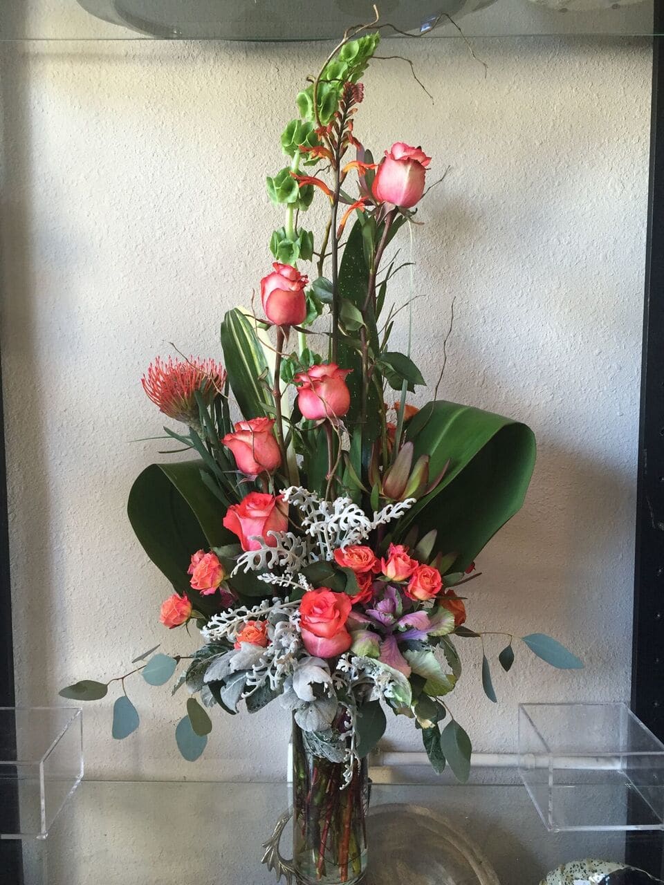 Tall floral arrangement with pink roses in a glass vase