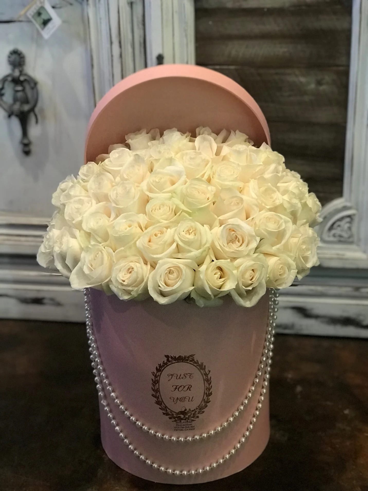 Cream rose bouquet in a pink hatbox with pearl trim