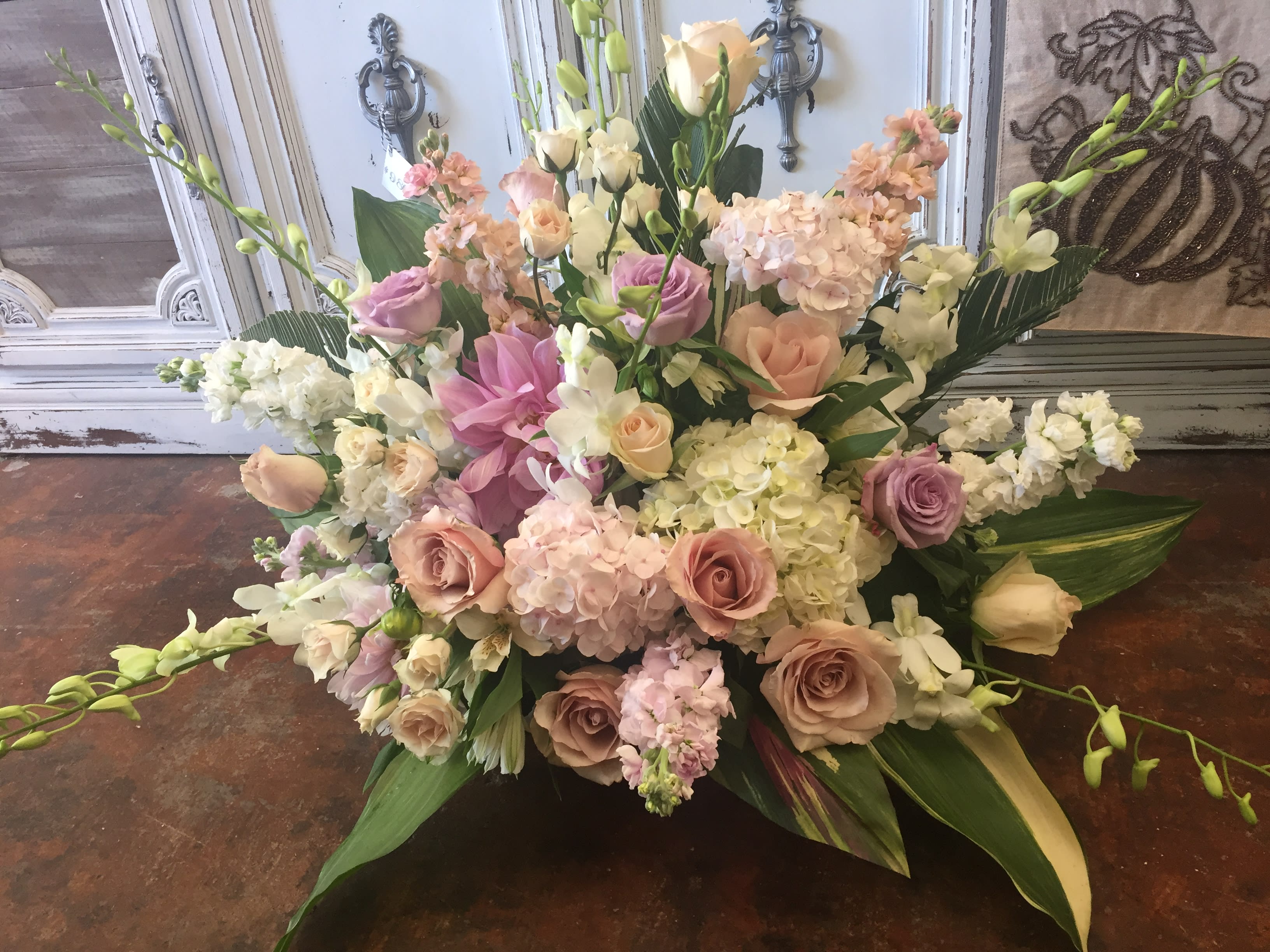 Large pastel floral arrangement with roses, hydrangeas, and lilies