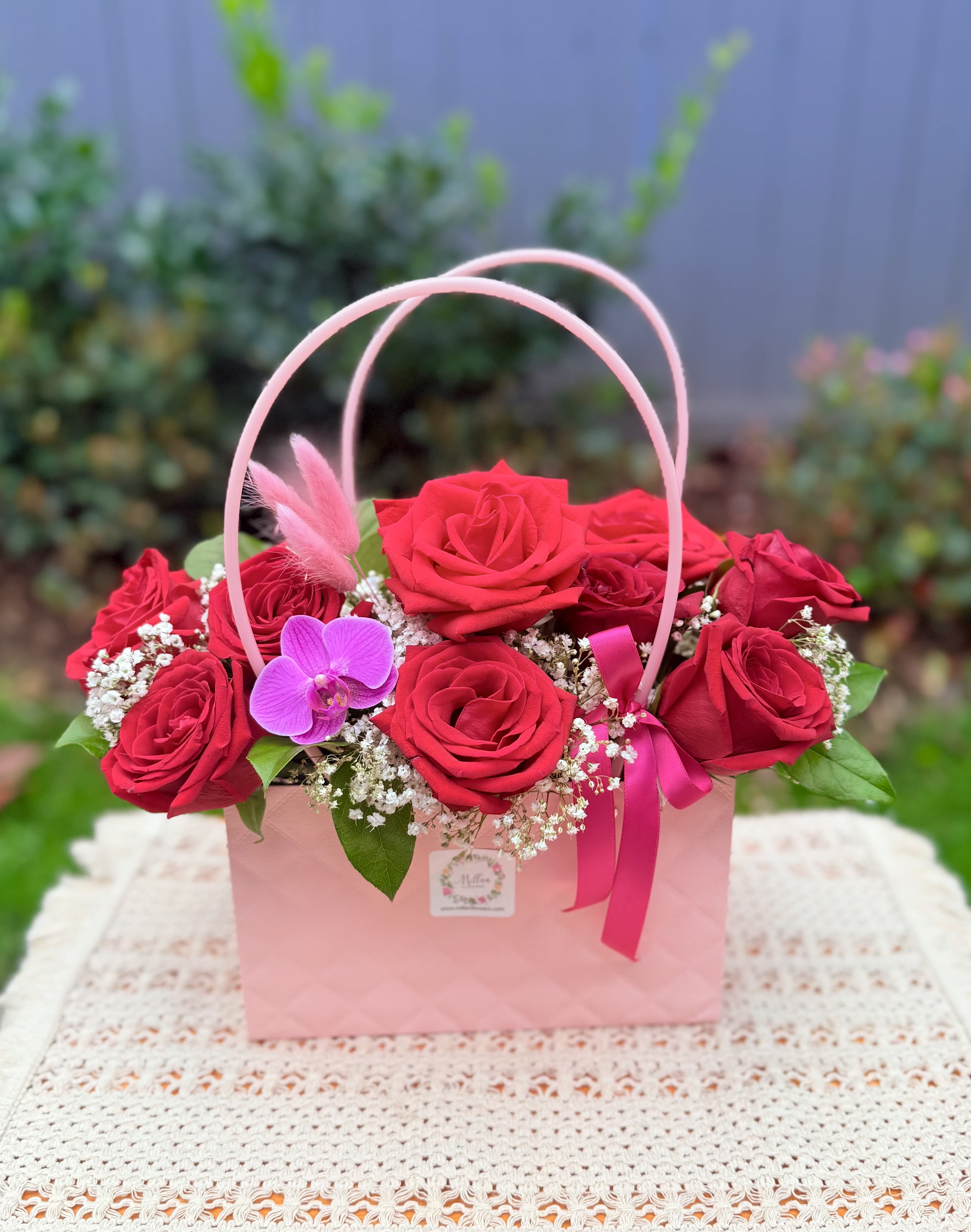 “ Thinking of You ” Red rose Arrangement - Express your love with these beautiful romantic red roses. This gorgeous floral design ( purse) is crafted with premium roses in freedom red color, gypsophila and seasonal fresh foliage. It’s accented with a beautiful and elegant purple orchid. Medium size  Red, pink and white tones  It’s perfect for anniversary, birthday, just because, thinking of you.