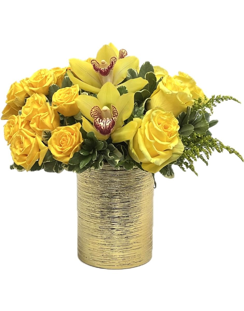 Low arrangement of yellow roses and orchids in a textured gold cylinder vase