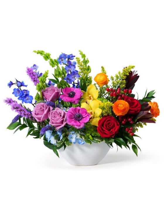 Colorful low flower arrangement in a white bowl-shaped vase
