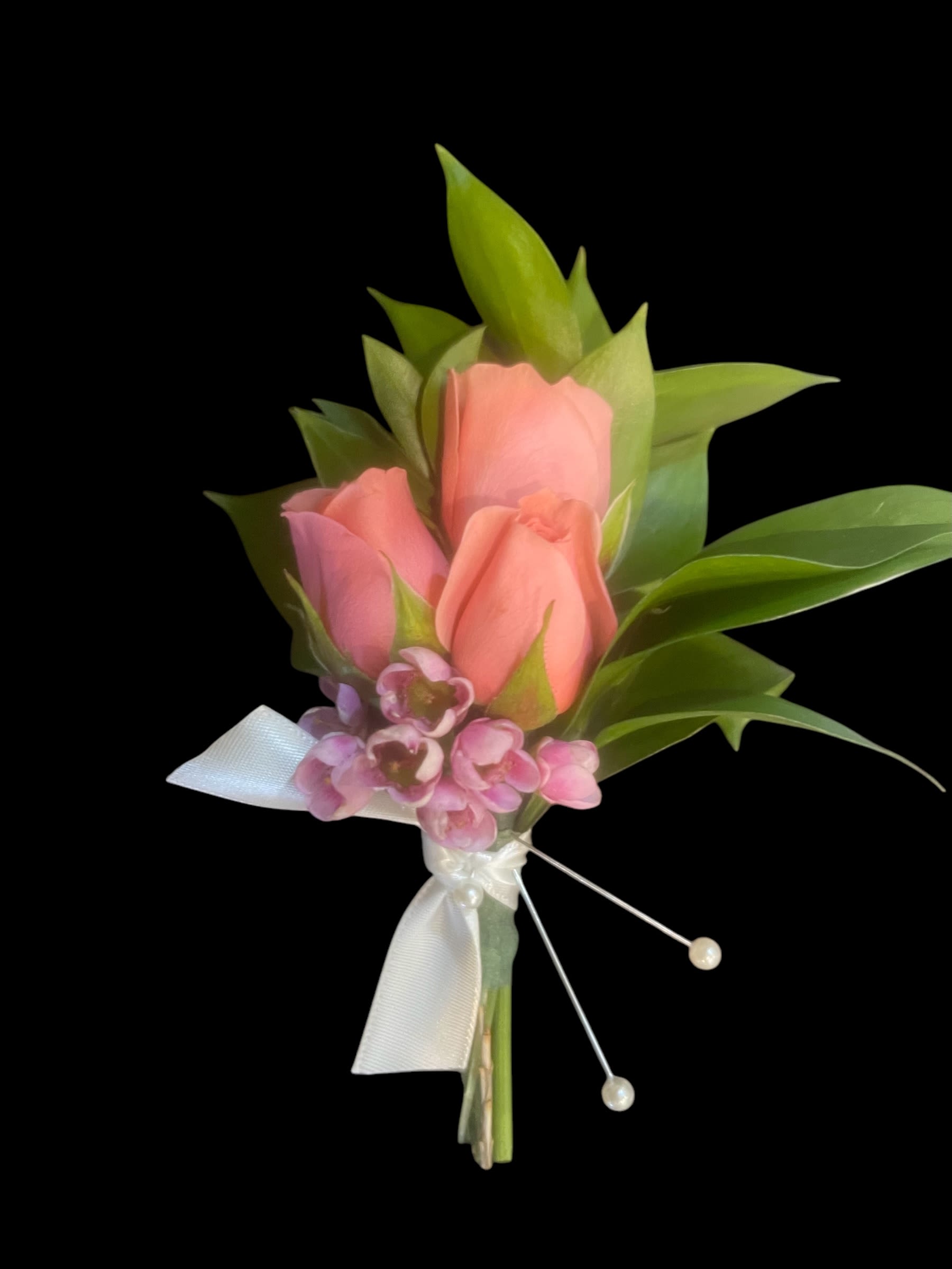 Pink Spray Rose Boutonnière  - Elevate your formal attire with the Triple Spray Rose Boutonniere with Ruscus, expertly handcrafted by Petals, your trusted local Wilmington, Delaware florist. This elegant boutonniere features three fresh spray roses accented with lush ruscus greenery, creating a sophisticated and timeless look perfect for weddings, proms, or other special occasions.  This product is not eligible for customization. Our designers will craft the bouquet to reflect the style of the picture.  Ideal for proms, homecomings, grooms, groomsmen, fathers of the bride or groom, or any formal attendee, this boutonniere is carefully arranged for a fresh, polished, and long-lasting floral accent. Each piece is handcrafted by Wilmington’s expert floral designers to ensure quality, elegance, and local freshness.  This product is not eligible for refunds after purchasing. 