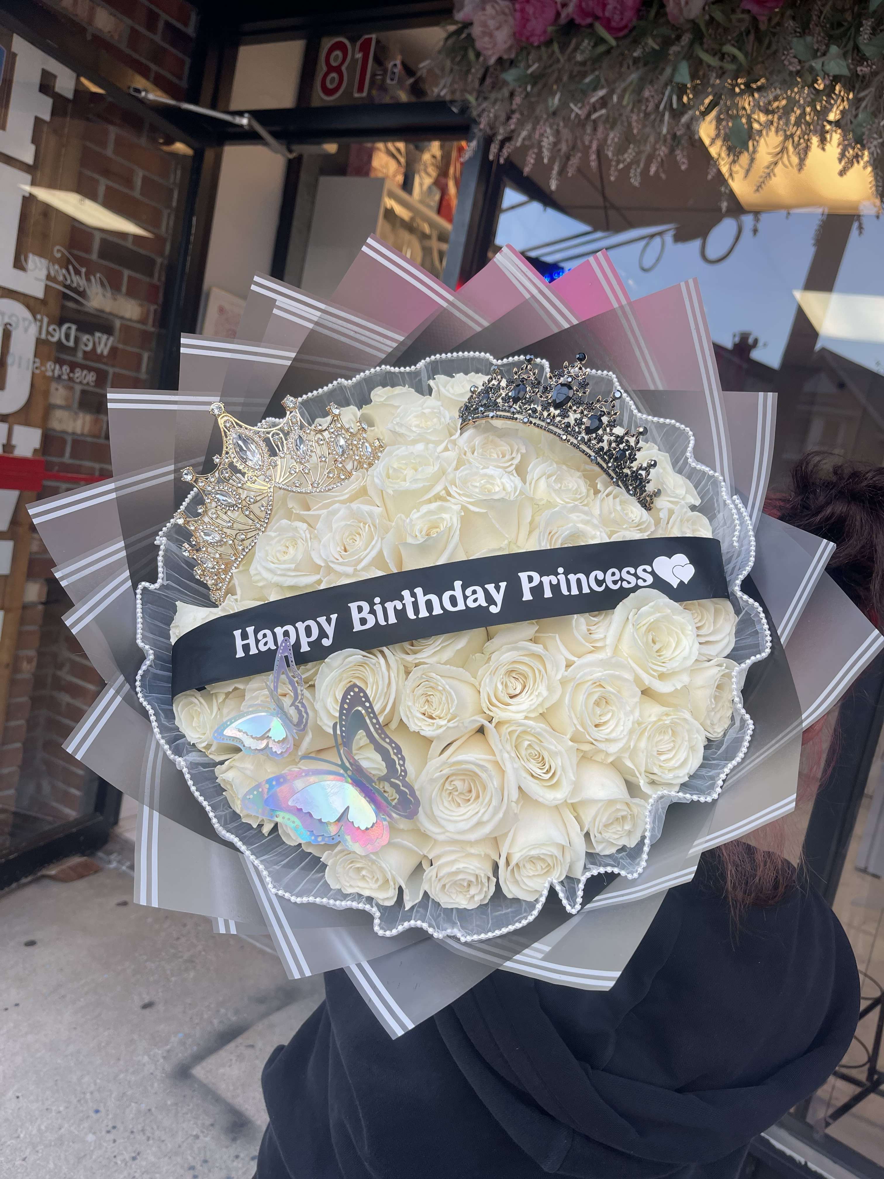 Bouquet of white roses with crowns and a birthday ribbon