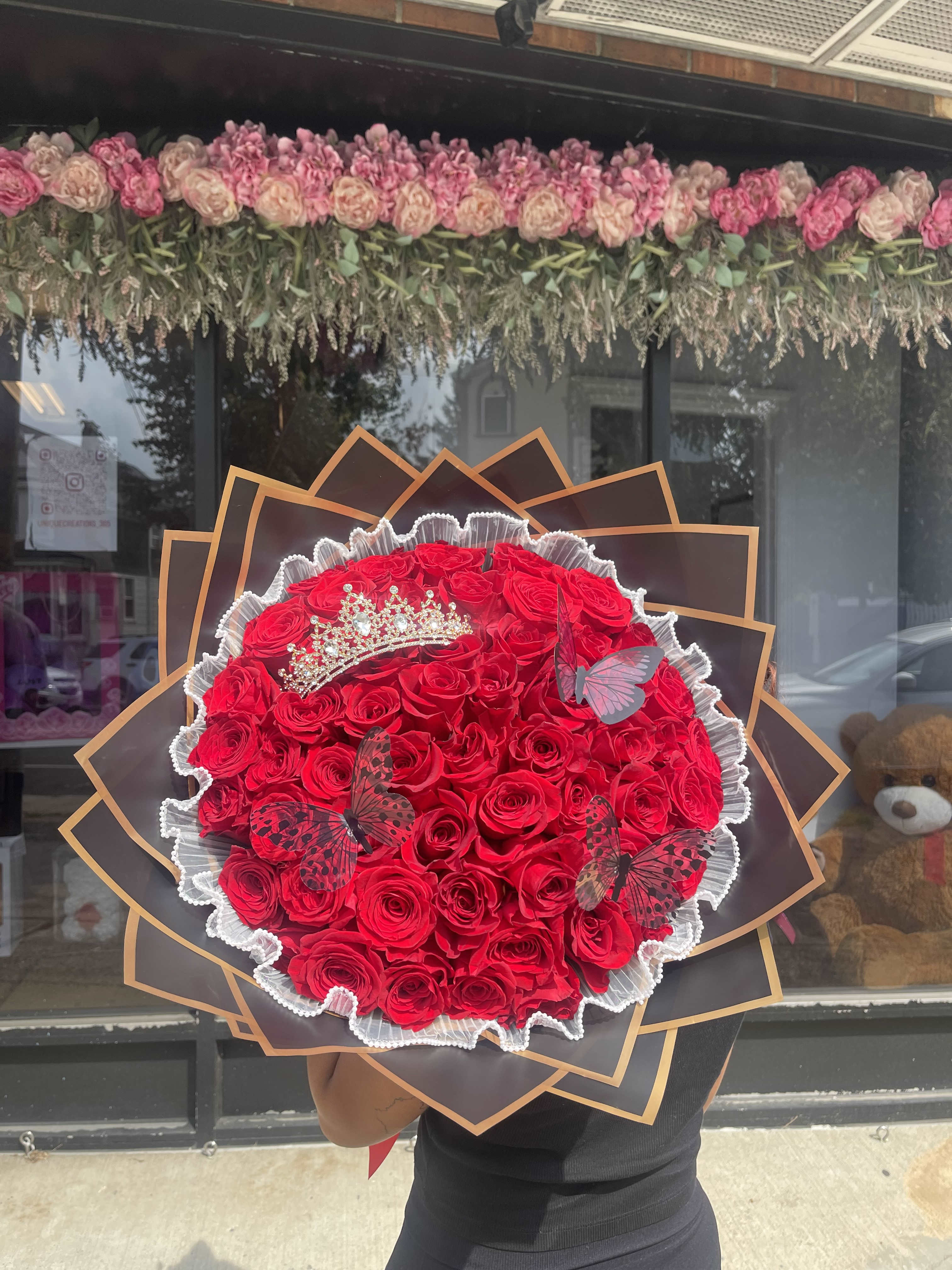 Large bouquet of red roses with a tiara and butterfly decorations