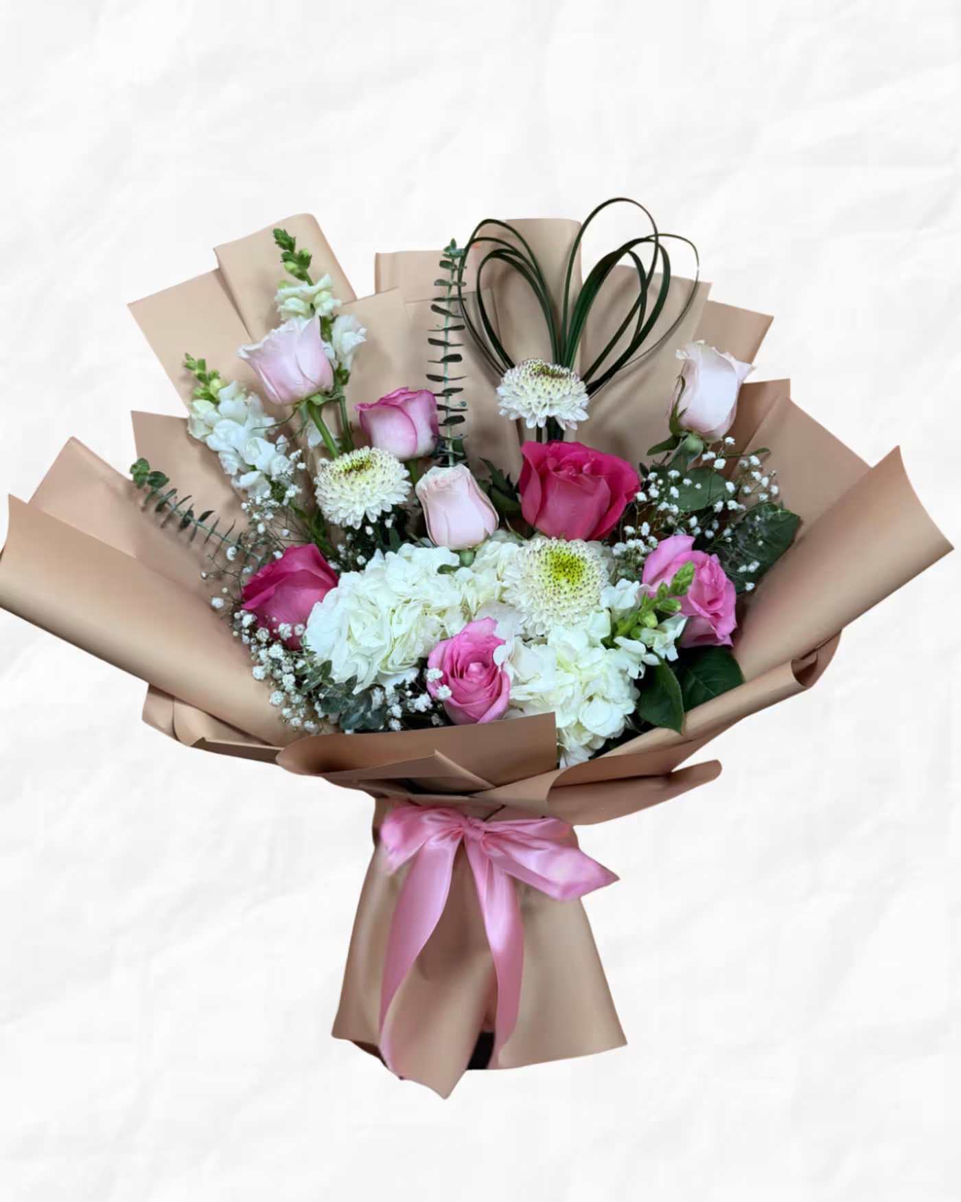 Bouquet of pink and white roses with hydrangeas in brown paper wrap