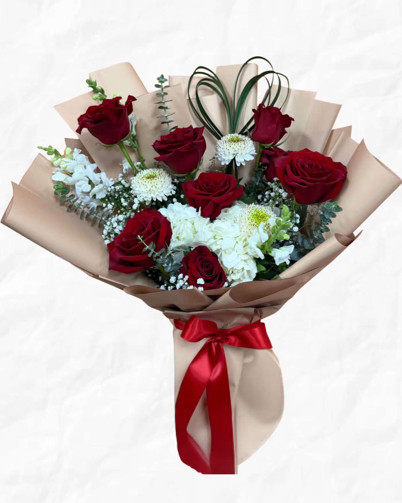 Bouquet of red roses and white flowers wrapped in beige paper with a red ribbon