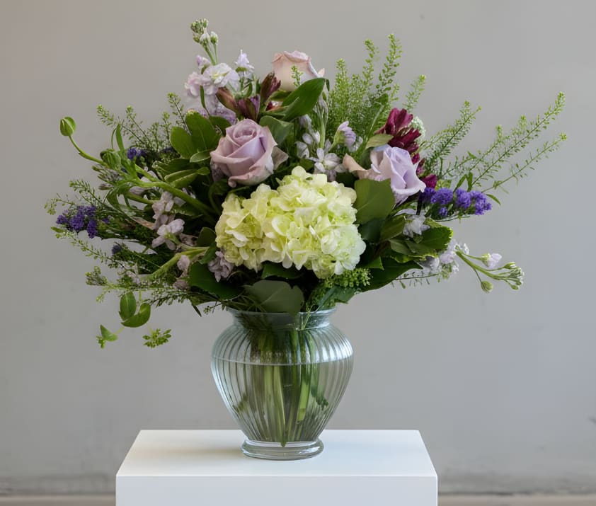 Moonlit Meadow Elegance - Soft lavender roses, airy garden blooms, and lush hydrangea create a naturally graceful design in Moonlit Meadow Elegance. Romantic, refined, and effortlessly sophisticated, this arrangement brings peaceful beauty to celebrations, heartfelt moments, and everything in between.