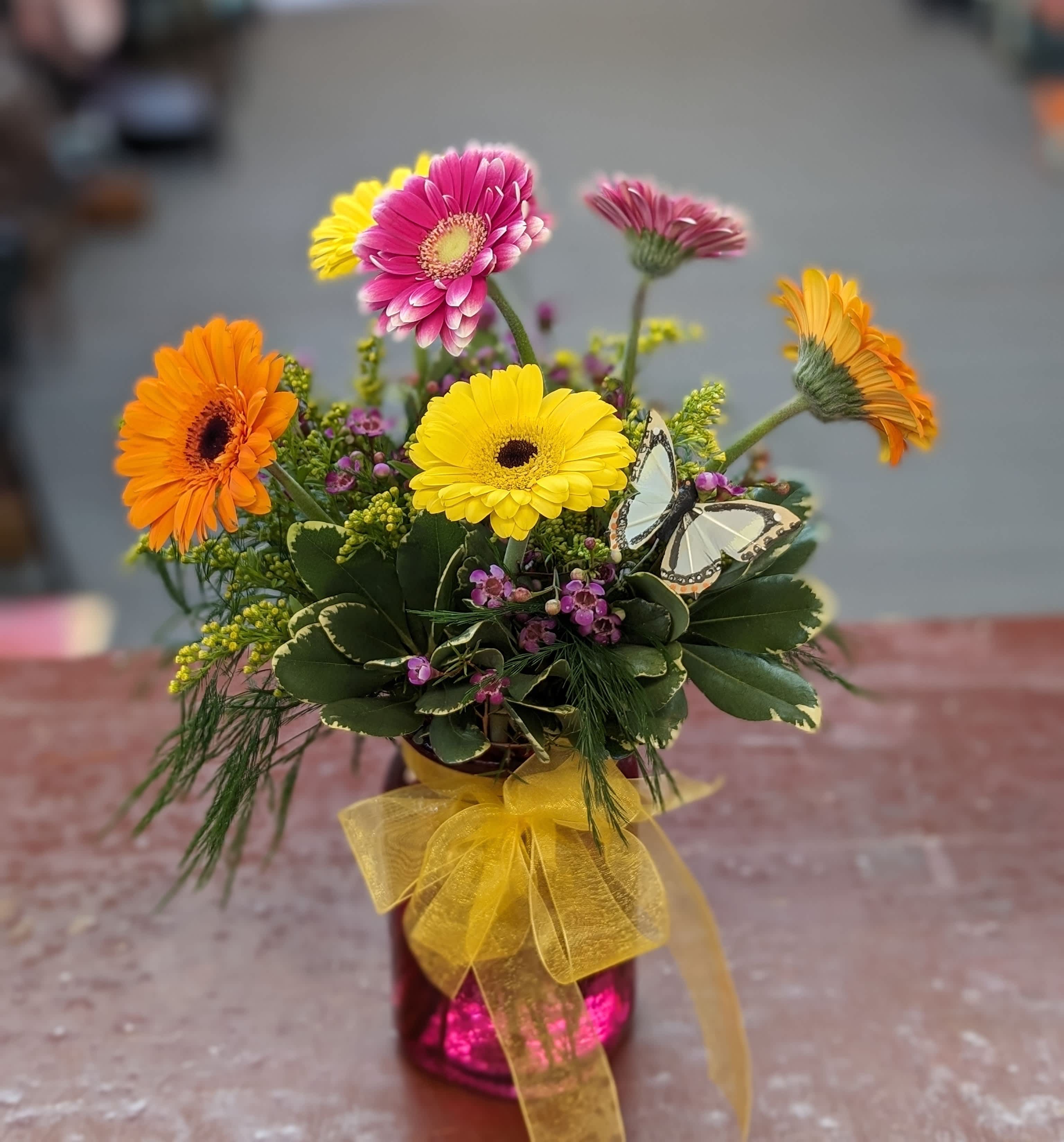 Gerber’s for a happy gift.  - Bright, cheerful gerbera daisies take center stage in this mixed-color flower arrangement-perfect as a birthday bouquet, a Mother's Day gift, or a sunny "get well" surprise. The playful combination of pink, yellow, orange and white gerberas immediately draws the eye, while the arrangement's whimsical butterfly pick and hot pink glass vase make it feel like a little celebration for the person you're thinking of. 
