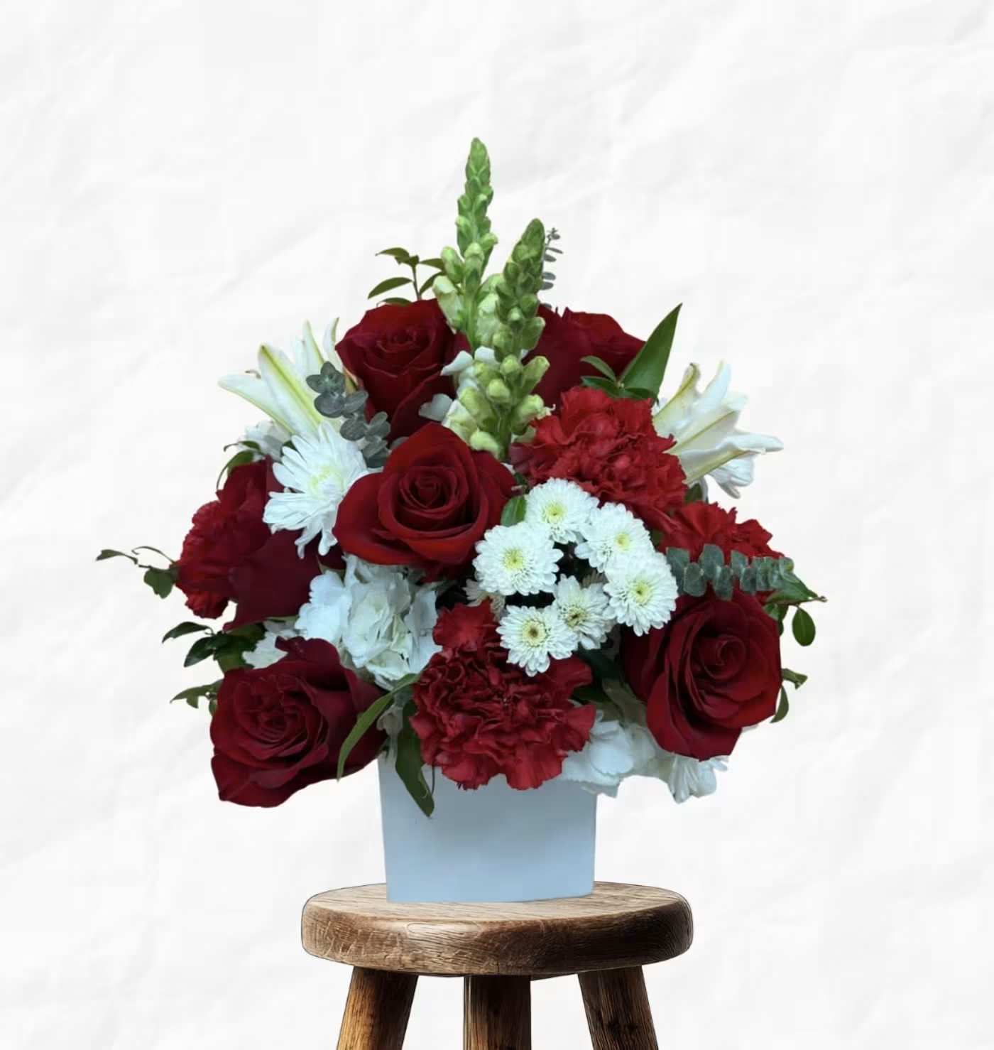 Red roses and white flowers in a light blue box