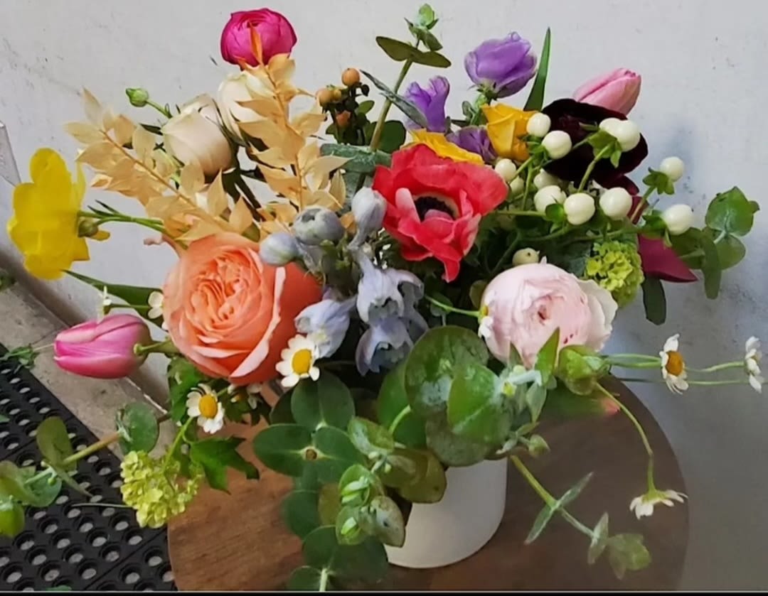 Mixed bouquet of colorful flowers in a white vase