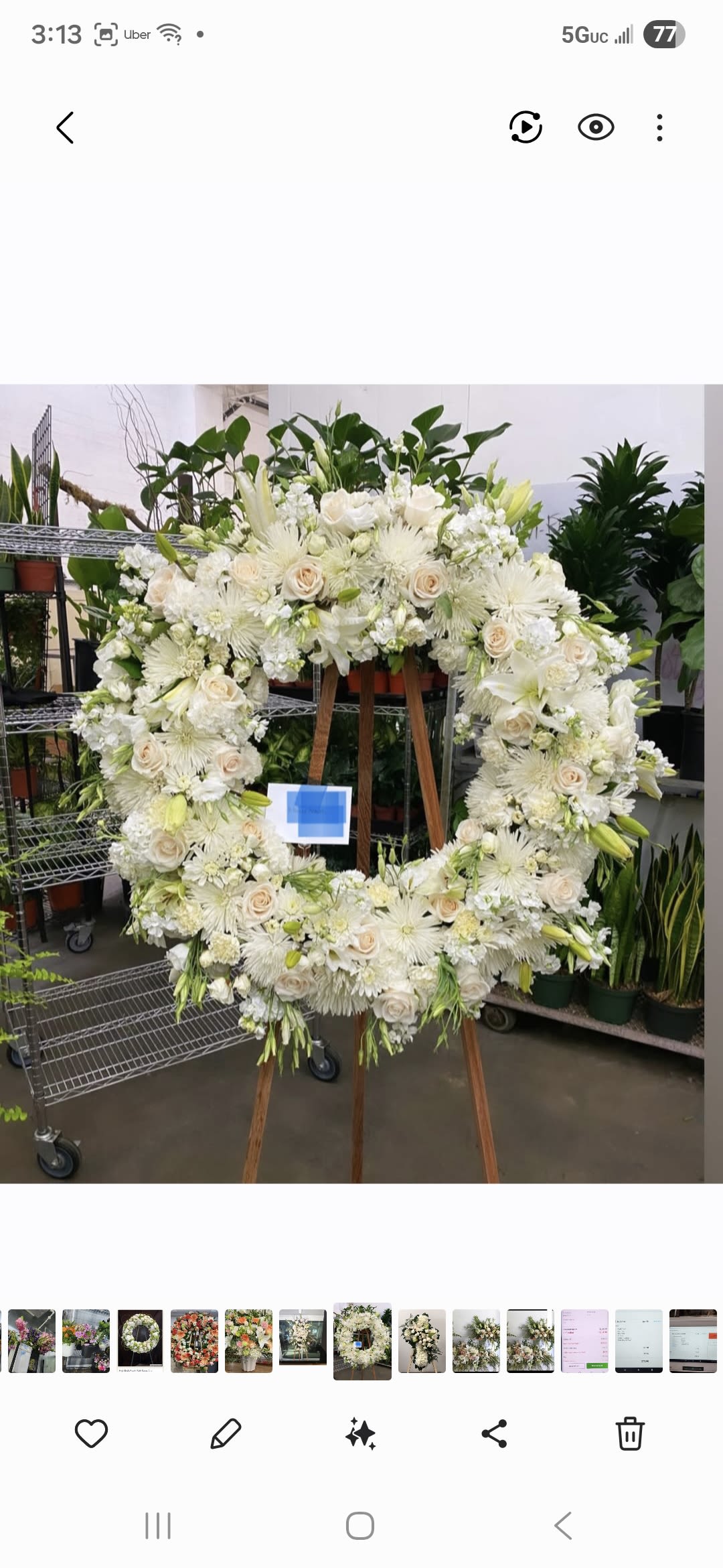 Large white floral wreath on a wooden easel