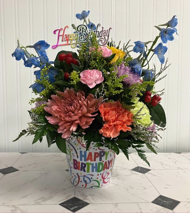Birthday Party Streamers - Celebrate their special day with a burst of color! Birthday Streamers features a vibrant rainbow mix of fresh flowers arranged in a festive birthday-themed container decorated with cheerful streamers. Bright, playful, and full of life, this arrangement is the perfect way to make someone’s birthday extra special.