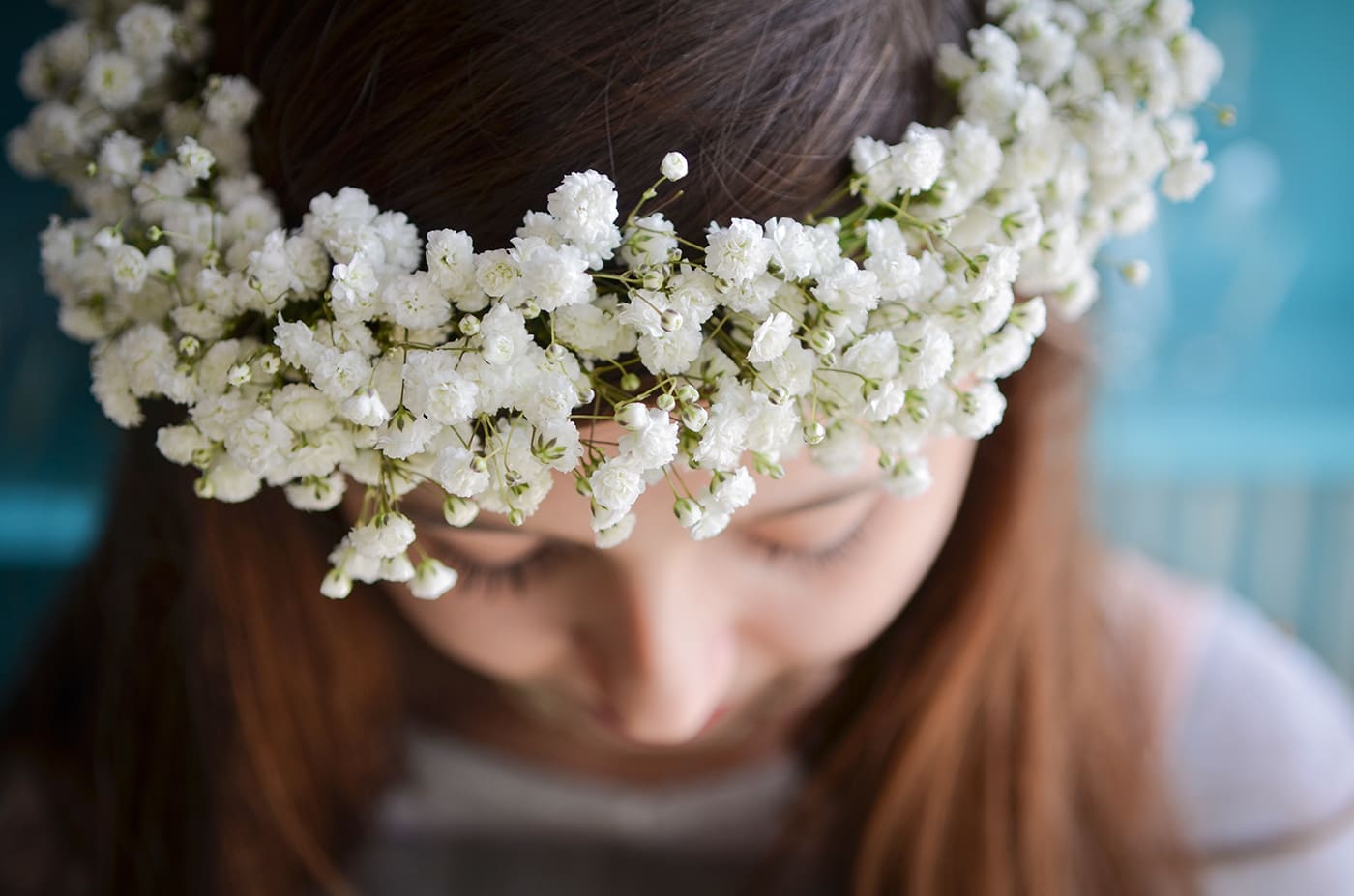 White baby’s breath flower crown worn on a girl’s head, viewed from above