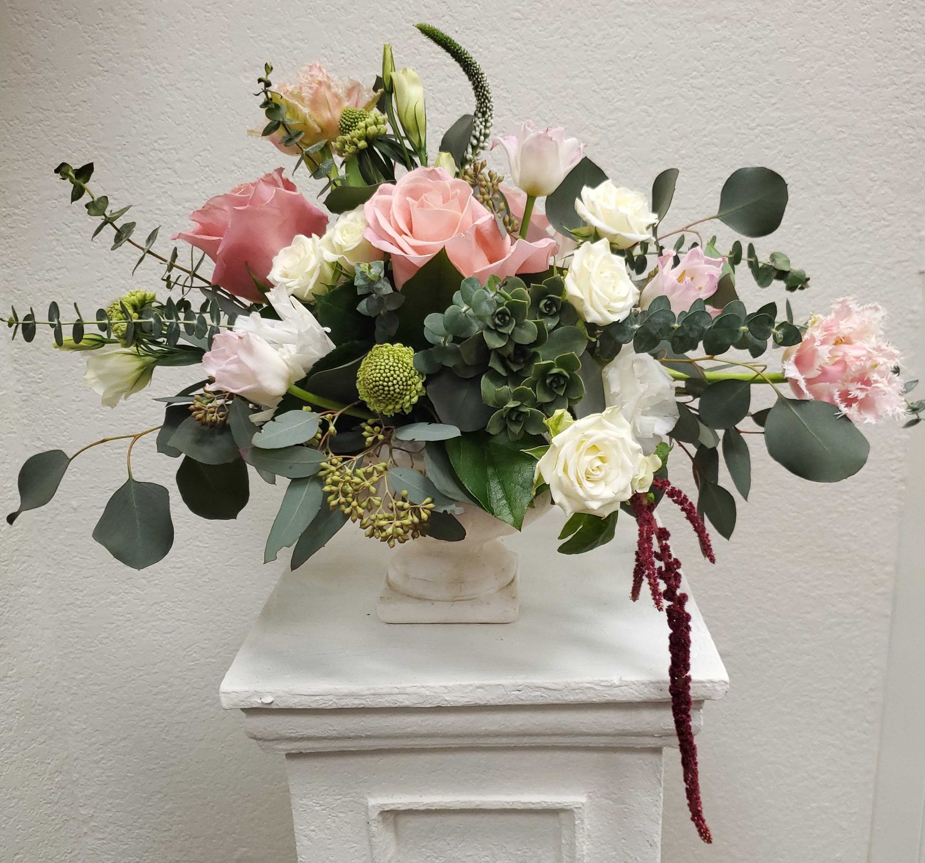 Mixed pink and white flower arrangement in a white vase