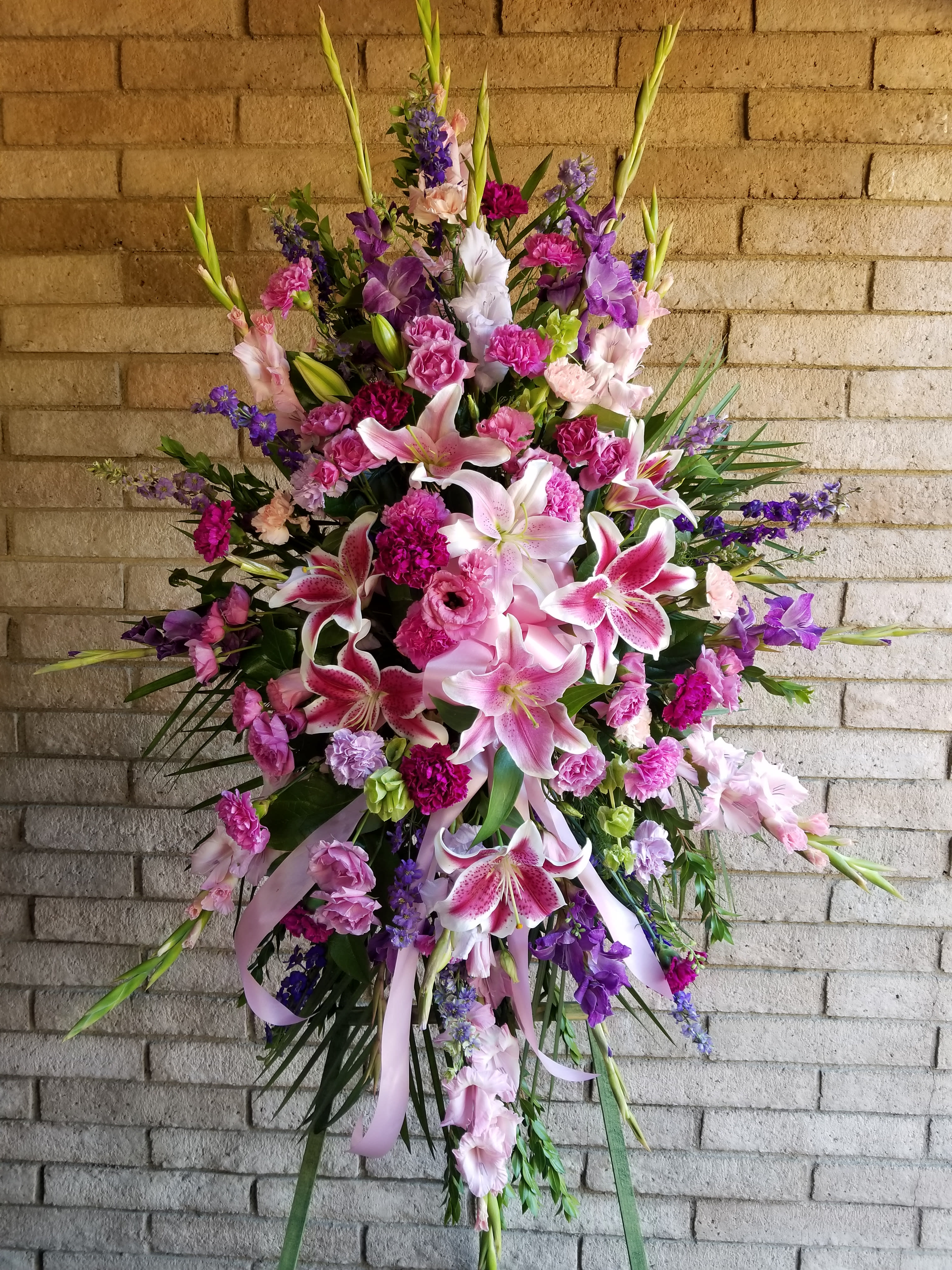 Large standing spray of pink and purple lilies and carnations