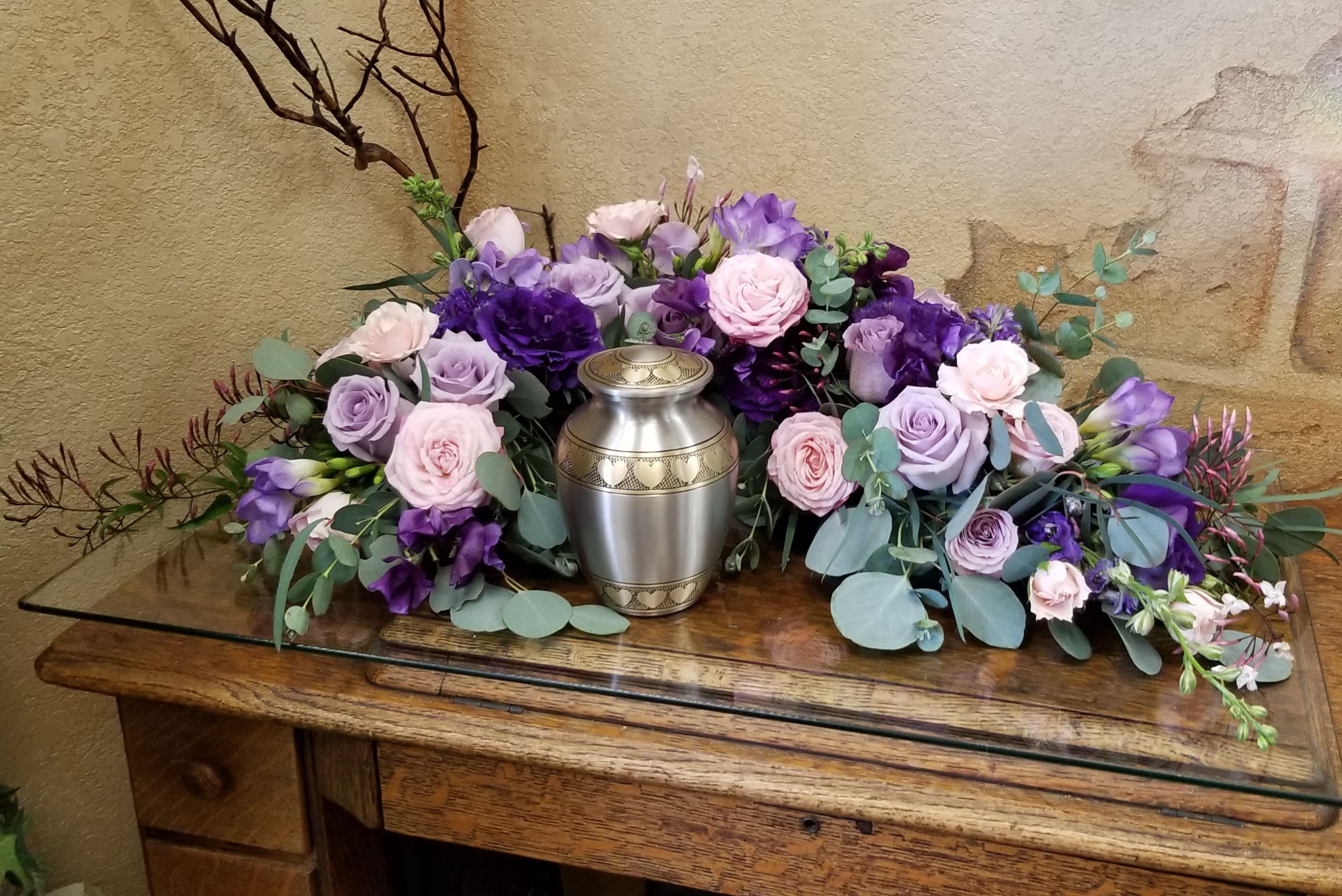 Lavender and pink roses arranged around a silver urn