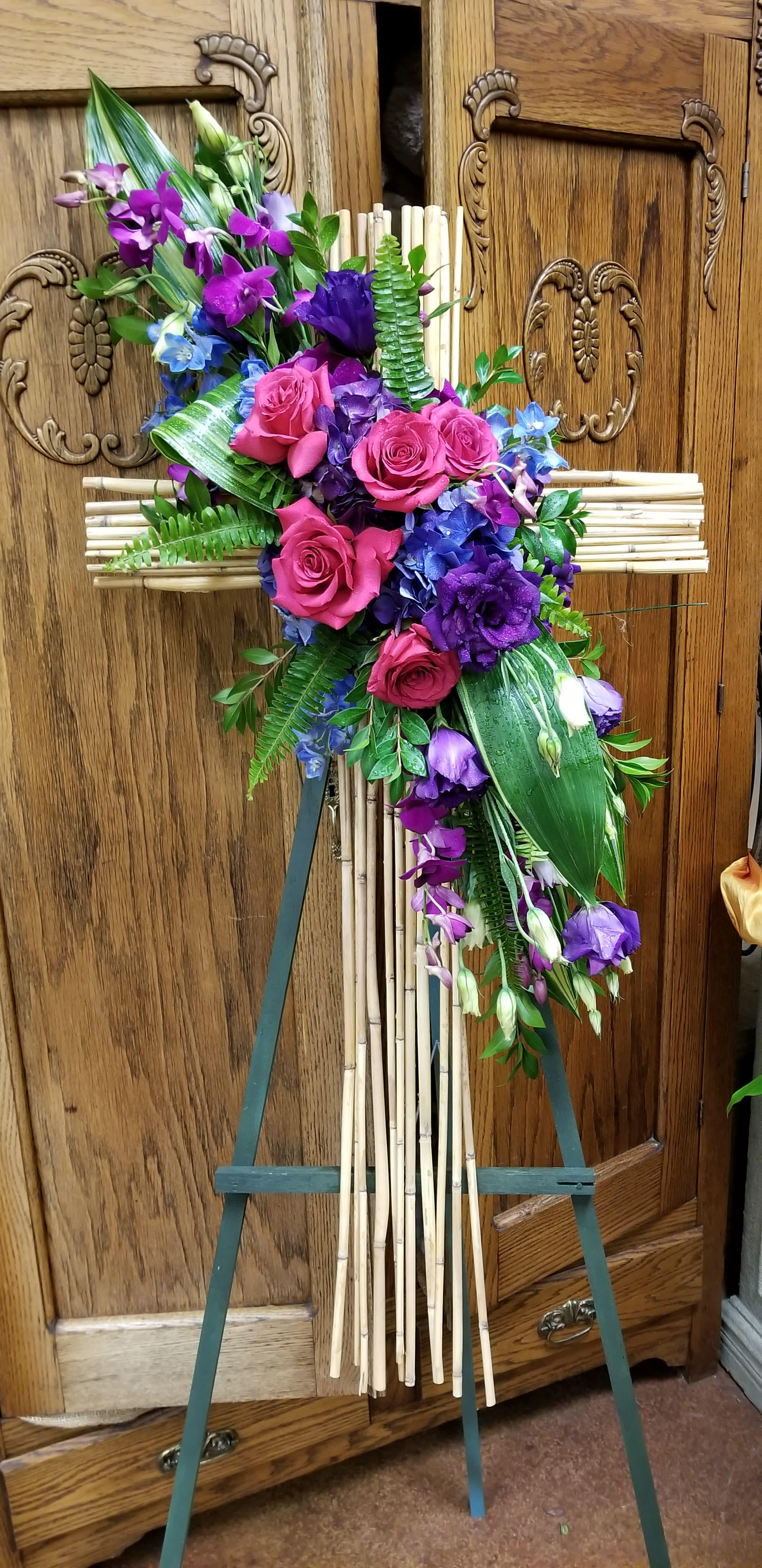 Purple and pink floral spray on a bamboo cross easel
