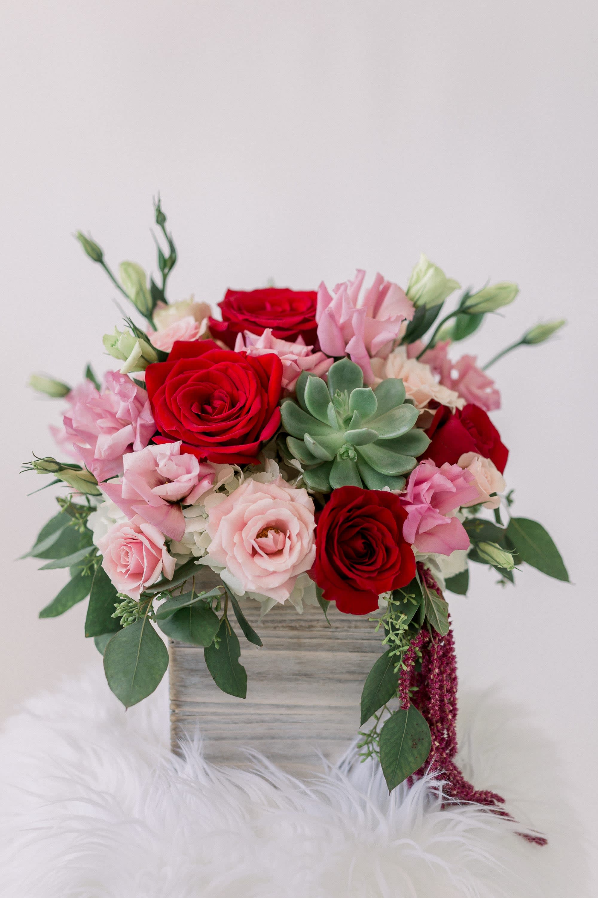 Pink and red rose bouquet with a succulent in a wooden box
