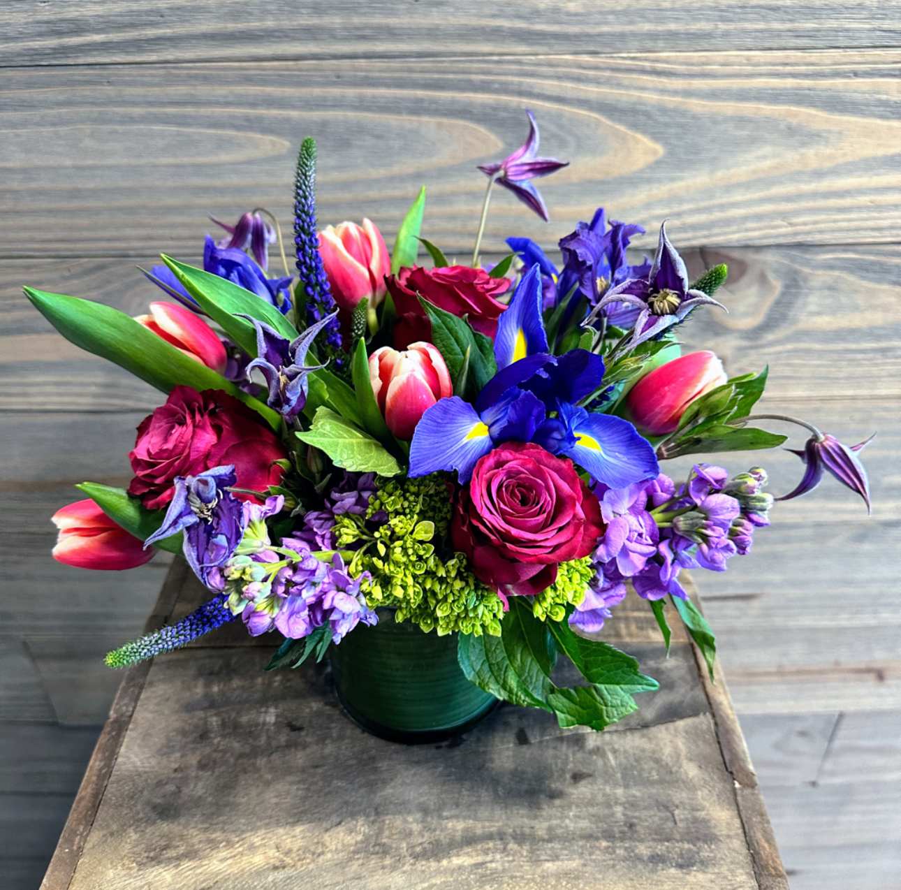 Midsummer Blooms - A low vase arrangement with a mix of bright pinks and shades of purple spring blooms, including iris, tulips and roses!