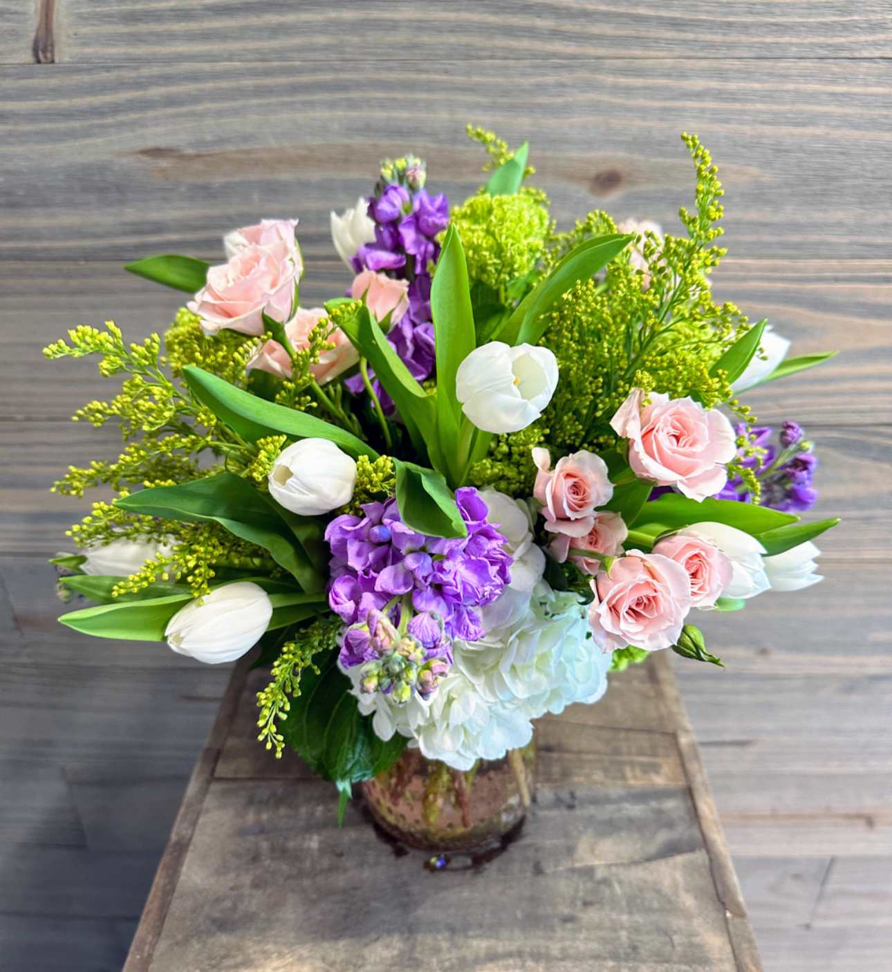 Demeter's Wish - A beautiful arrangement of soft spring blooms in a specialty glass vase.