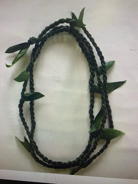 Braided dark green floral lei with scattered leaves