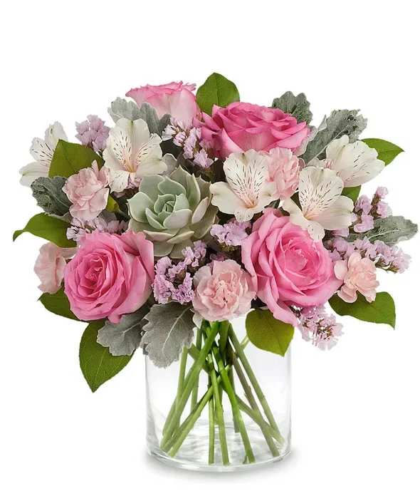French Garden - Vive La France! This exquisite arrangement featuring enchanting Pink Roses, beautiful  Ivory Alstroemeria,  Pink Miniature Carnations, and elegant Pink Sinuata Statice, accented with a stunning Echeveria Succulent and lush  greenery. Presented in a short cylinder glass vase, this arrangement exudes beauty and tenderness, making it the perfect gift to express your appreciation for Mom. Customize your gift with a personalized message for a truly heartfelt touch. 
