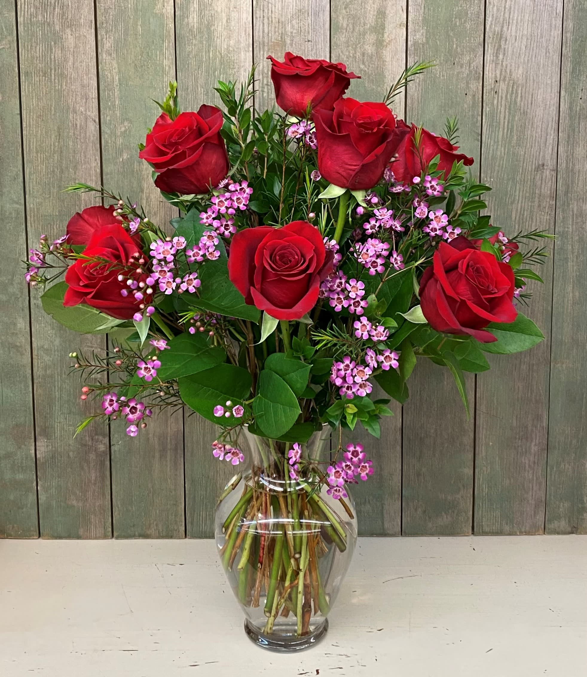 Red roses and pink filler flowers in a clear glass vase