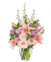 Pink lilies and roses in a clear glass vase