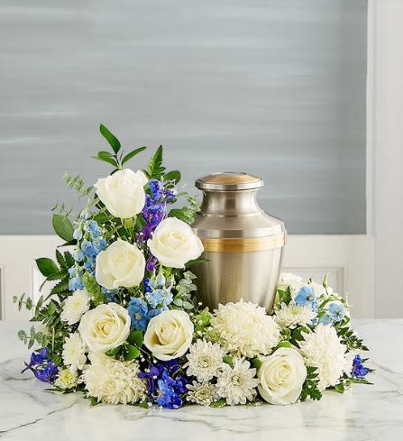 Cremation Wreath - blue -  Pet Friendly? No This arrangement contains Eucalyptus and Chrysanthemums (Mums), both of which are toxic to cats and dogs if ingested. Keep this tribute out of reach of household pets and avoid placing it in homes with curious cats.    Human Allergy Note : This arrangement contains Mums and Asters, which are known to carry high pollen counts. If the recipient is sensitive to hay fever, consider placing the wreath in a well-ventilated area and avoid direct contact with bedding or upholstery.   Care &amp; Longevity : To keep these blooms vibrant, check the floral foam base daily and add water to keep it consistently damp. Avoid placing the wreath near heating vents, direct sunlight, or drafty doorways. As individual flowers fade, gently pinch them off to maintain the beauty of the remaining display.    Best Occasions &amp; Situations : - Funeral service - Celebration of life - Memorial niche decoration - Anniversary of passing - Church altar tribute - Home memorial display   Why Customers Love It : - Serene Color Balance: The mix of white and blue offers a calming, dignified presence. - Unique Silhouette: The asymmetrical height adds a modern touch to a traditional wreath. - Gift-Ready: Arrives fully designed and ready for immediate display at a service. - Symbolic Meaning: Combines the “circle of life” shape with flowers representing peace and remembrance.