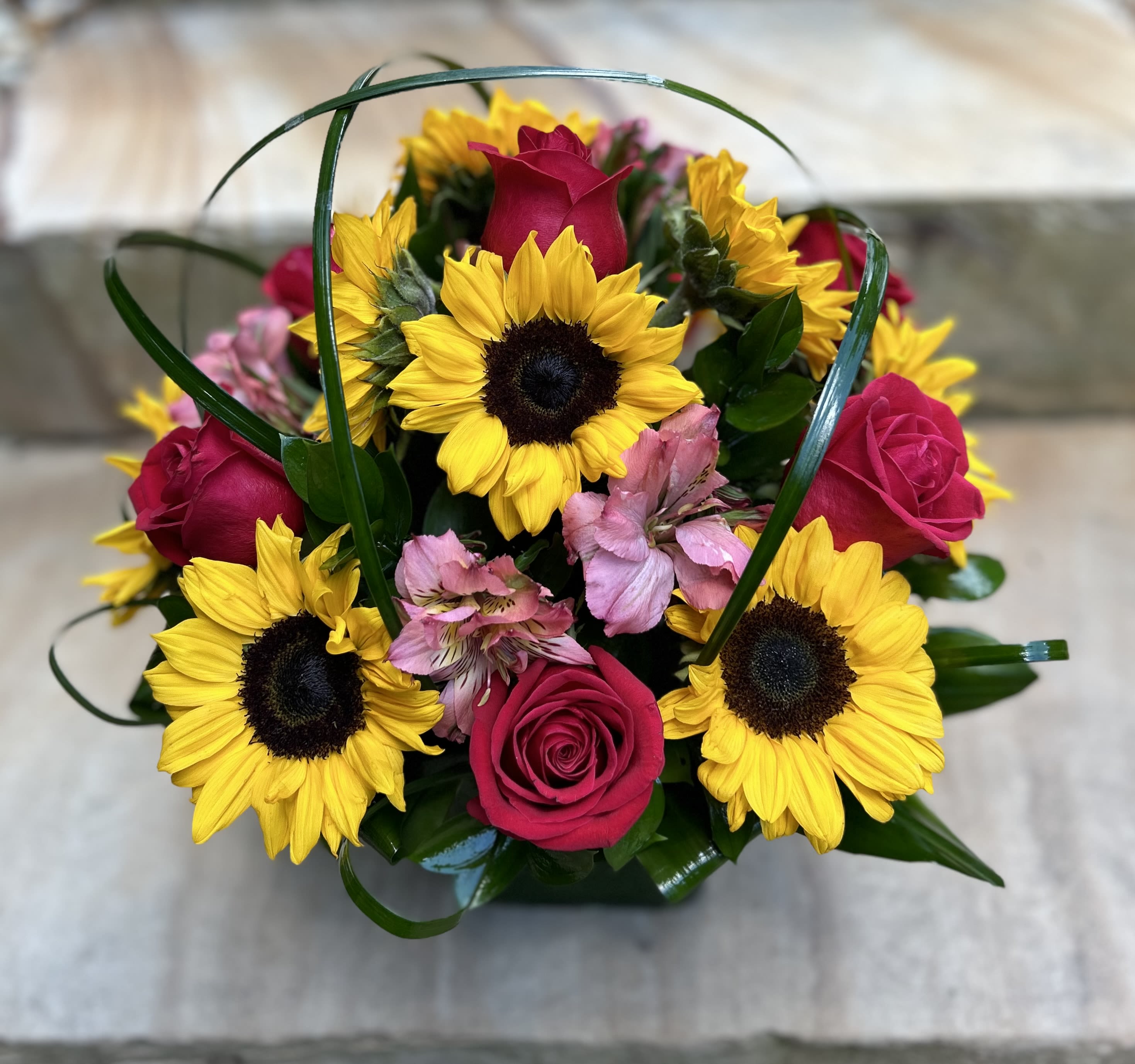 Bouquet of yellow sunflowers, pink roses, and pink alstroemeria