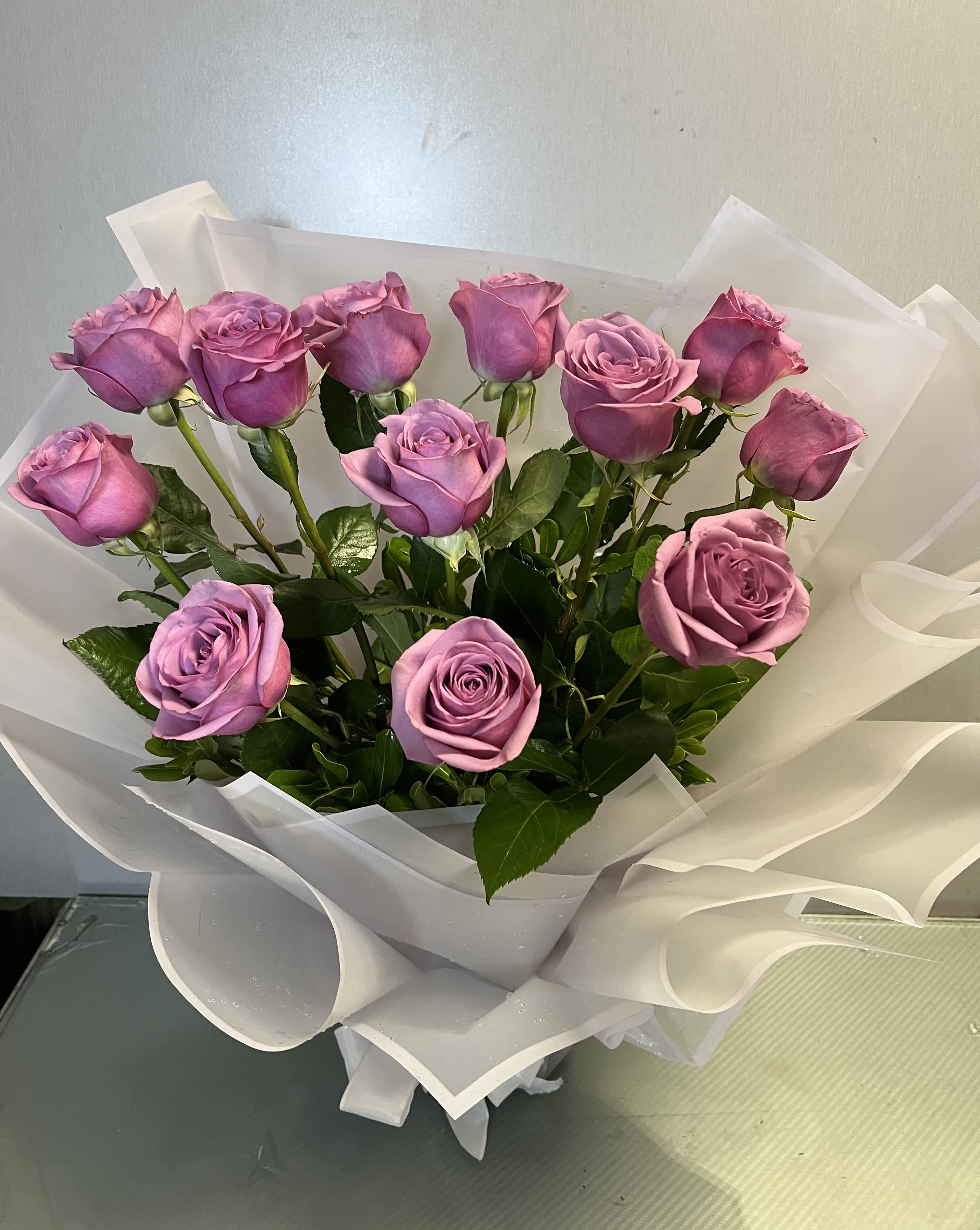Bouquet of lavender roses wrapped in white paper