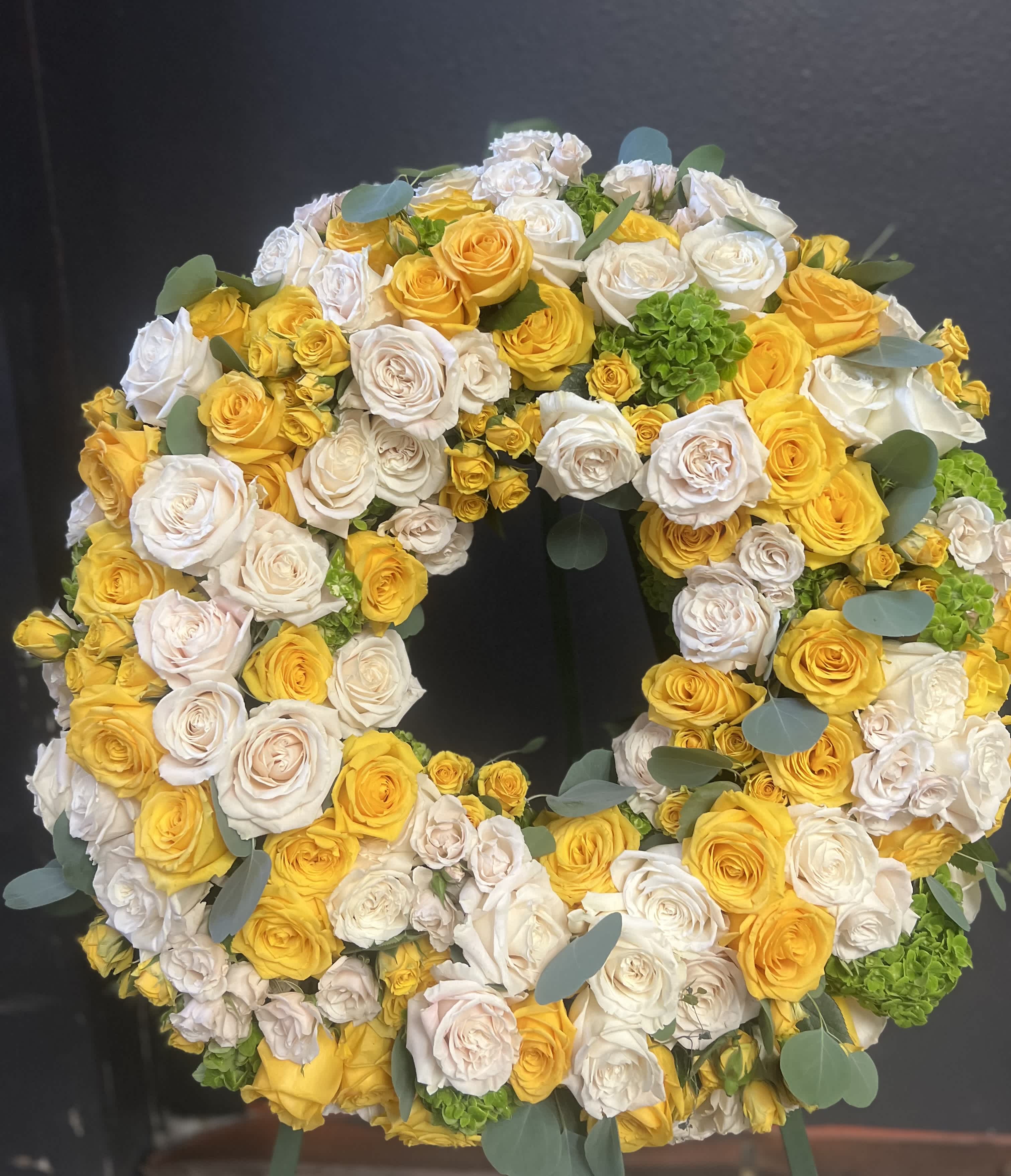 Large circular wreath of yellow and white roses with eucalyptus accents
