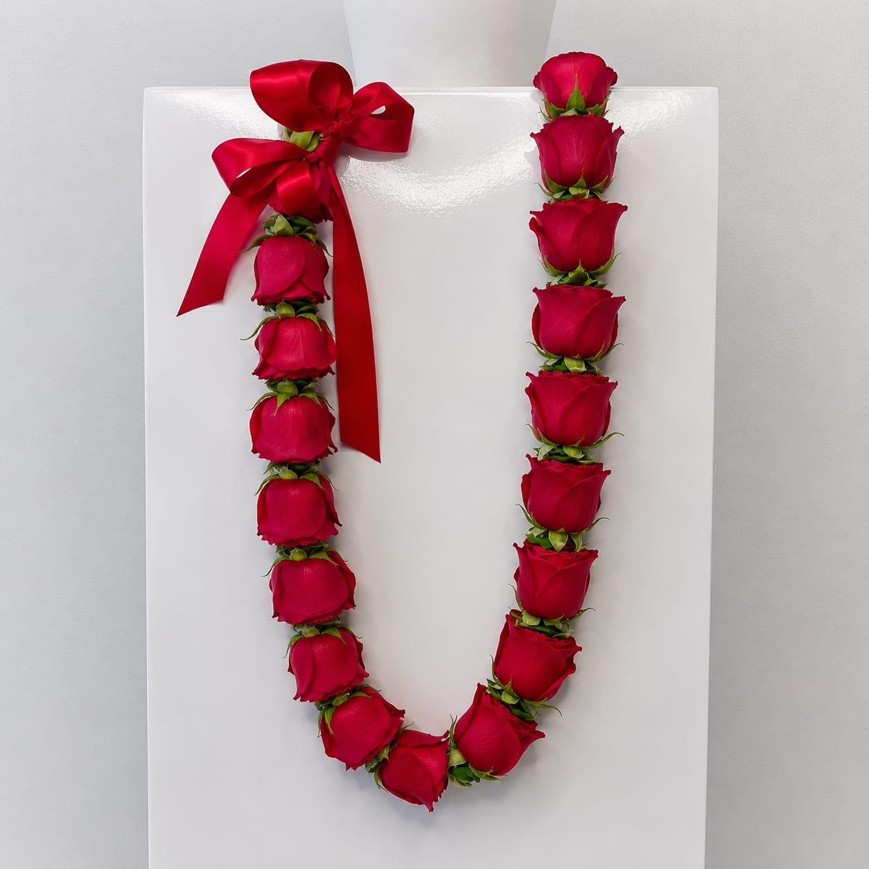 Rose Lei - Celebrate a meaningful milestone with a stunning rose graduation lei, handcrafted in-house for a fresh, elegant, and memorable presentation. Designed with premium roses, each lei is carefully hand-strung to create a full, luxurious look that beautifully honors your graduate’s achievement.  Available in a variety of colors including red, pink, lavender, yellow, peach, and white, each rose lei can be chosen to reflect school colors, personal style, or the sentiment you want to convey. From bold and vibrant to soft and romantic tones, these leis create a standout accessory that looks beautiful in graduation photos and ceremonies.  Roses symbolize love, pride, and celebration, making them a perfect choice for marking such an important accomplishment. The carefully arranged blooms provide a balanced, elegant drape that is comfortable to wear while maintaining a polished, high-end appearance.  Ideal for high school and college graduations, this rose lei adds a meaningful and timeless touch to your celebration. Whether you’re gifting it to a loved one or honoring your own achievement, it’s a beautiful way to make the day even more special.  Order your rose graduation lei today for pickup or delivery, and celebrate with a handcrafted floral piece designed to impress.