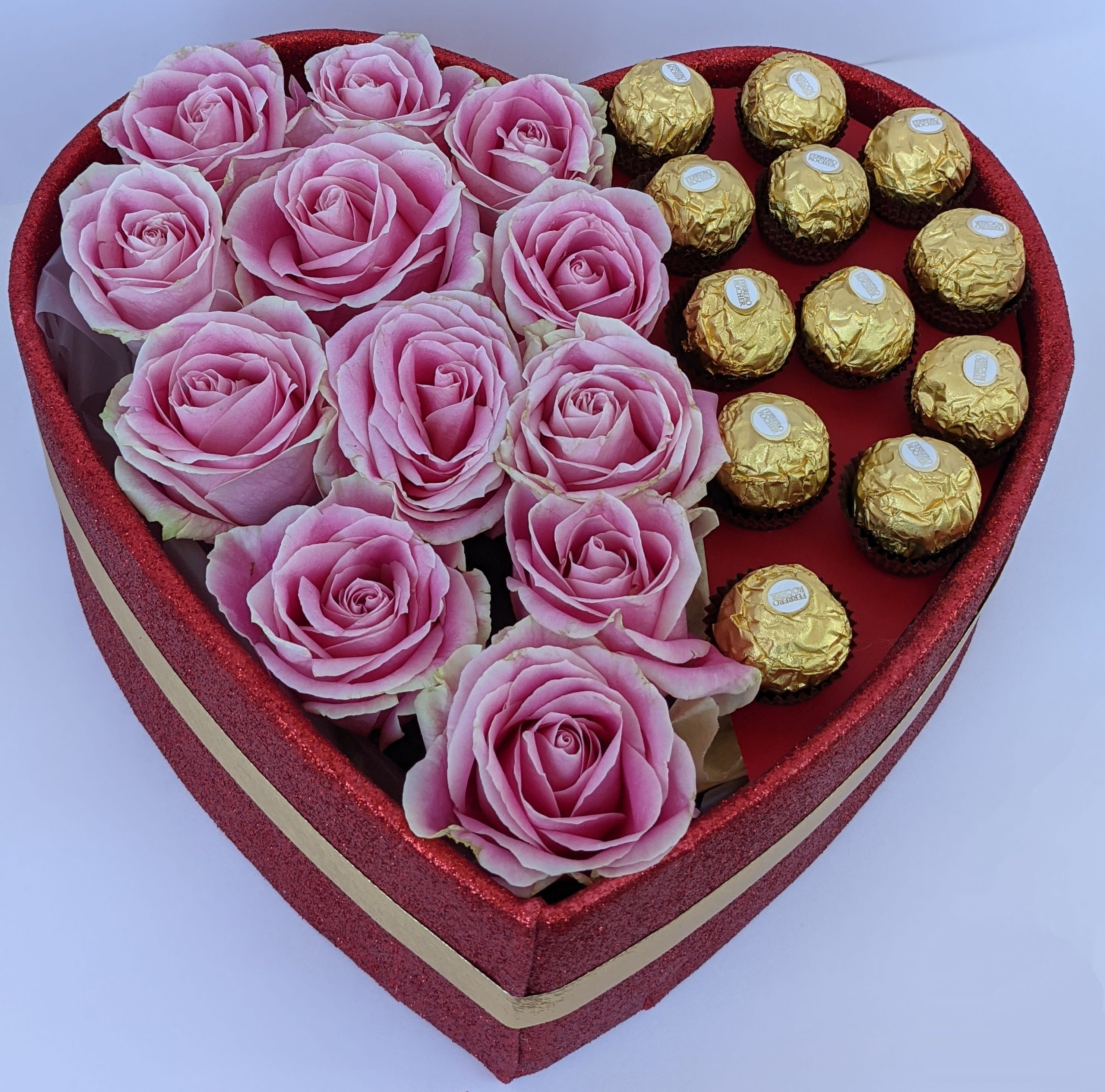 Heart-shaped box with pink roses and gold-wrapped chocolates