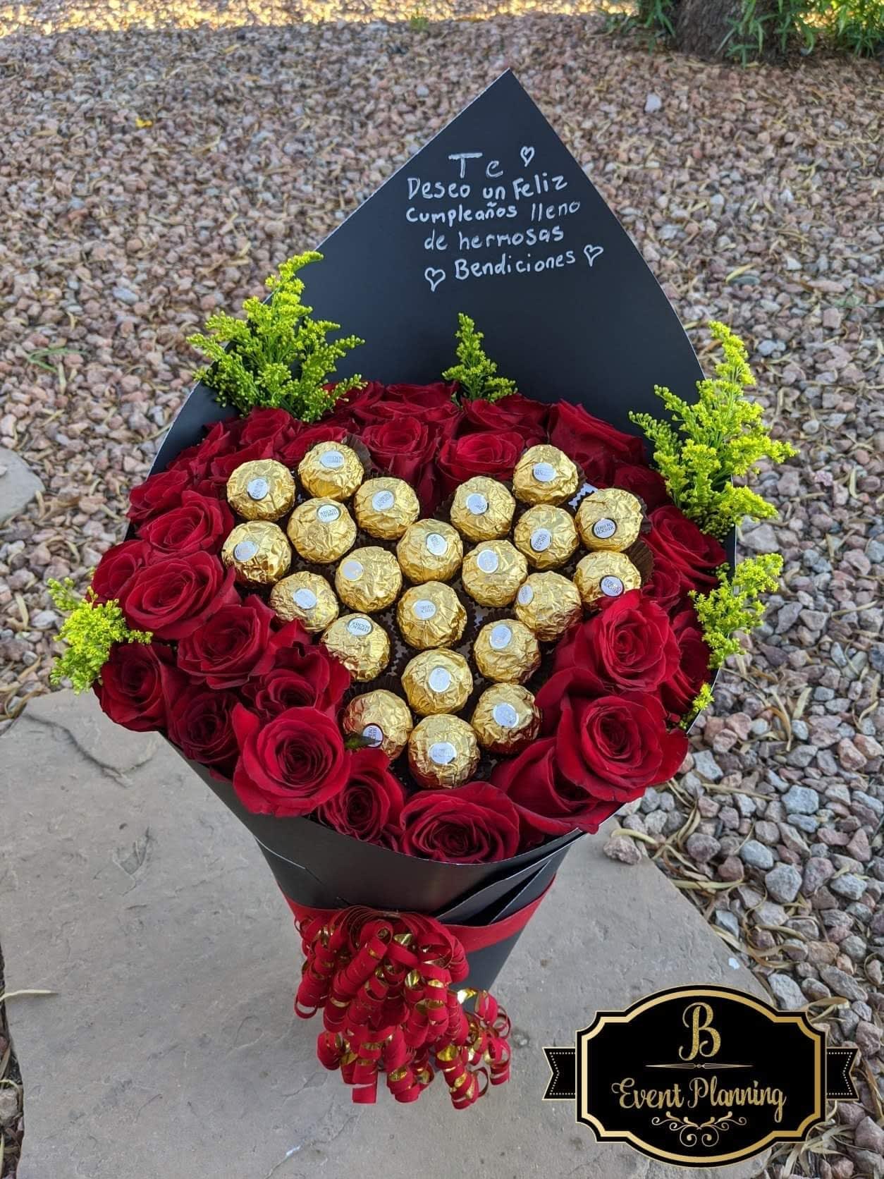 Heart-shaped bouquet of red roses with gold-wrapped chocolates and a black card