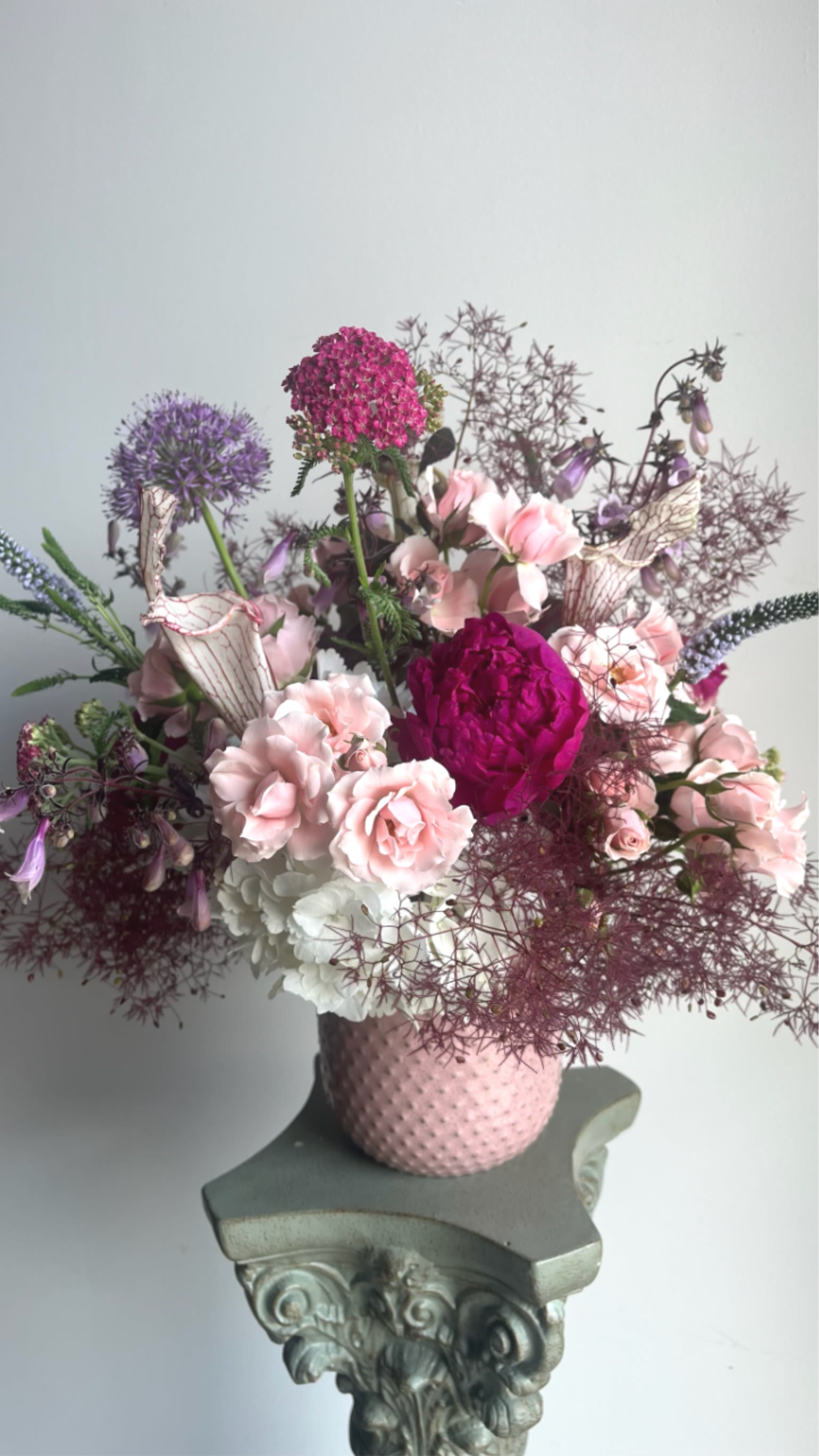 Lady in Pink - A graceful blend of soft blush and rich rosy pink blooms, Lady in Pink is designed with layered textures and seasonal florals that feel both feminine and artful. Moody deeper pink tones add depth and drama, while lighter blooms soften the palette for an elegant, balanced look. Arranged in a refined vase with fresh seasonal flowers, this design makes a beautiful statement for birthdays, celebrations, sympathy, or simply because.