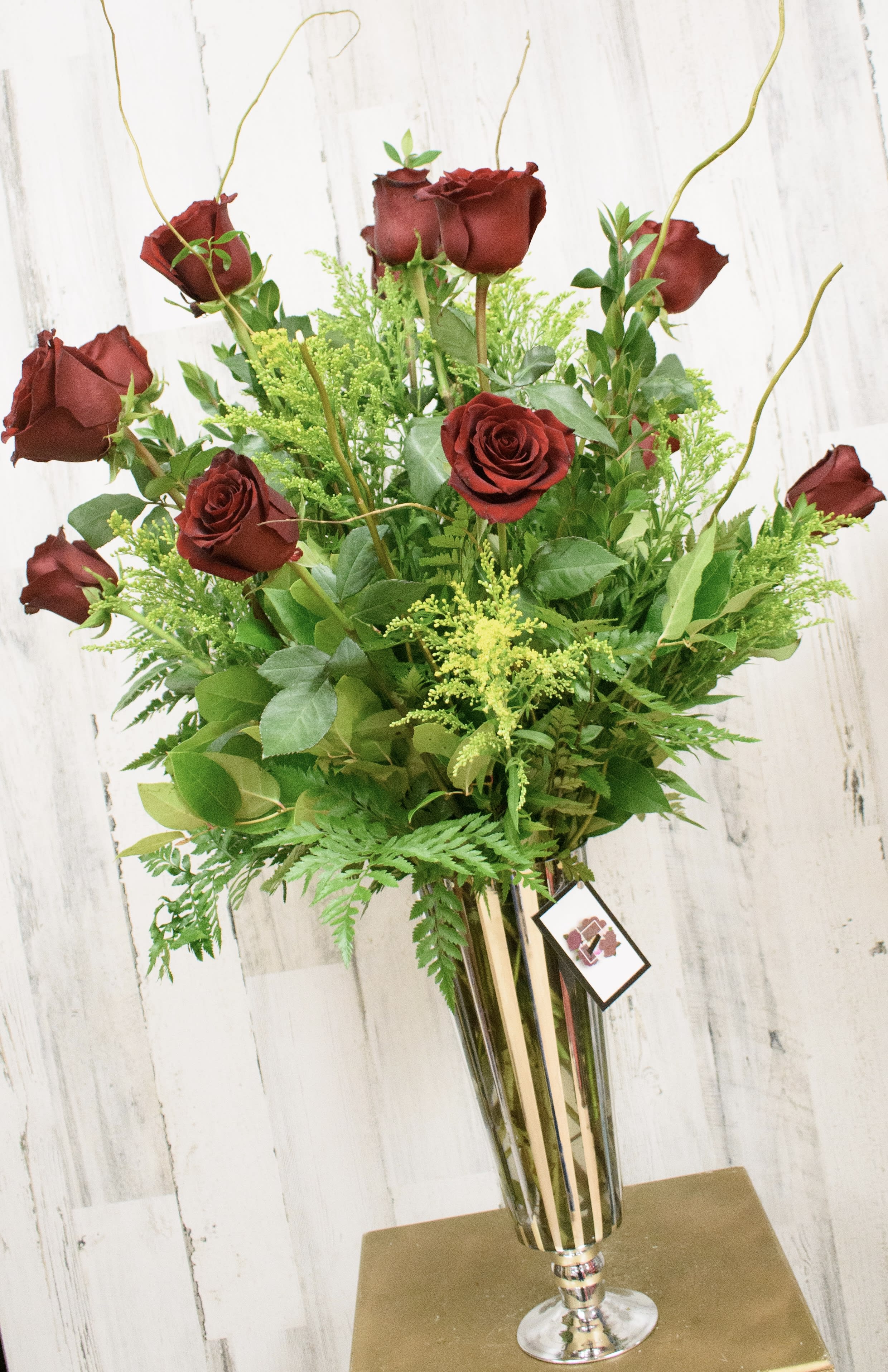 Premium Dozen  - Premium one dozen large headed long stem red roses in a glamorous tall vase with beautiful filler and curly willow branches. Sure to impress. 